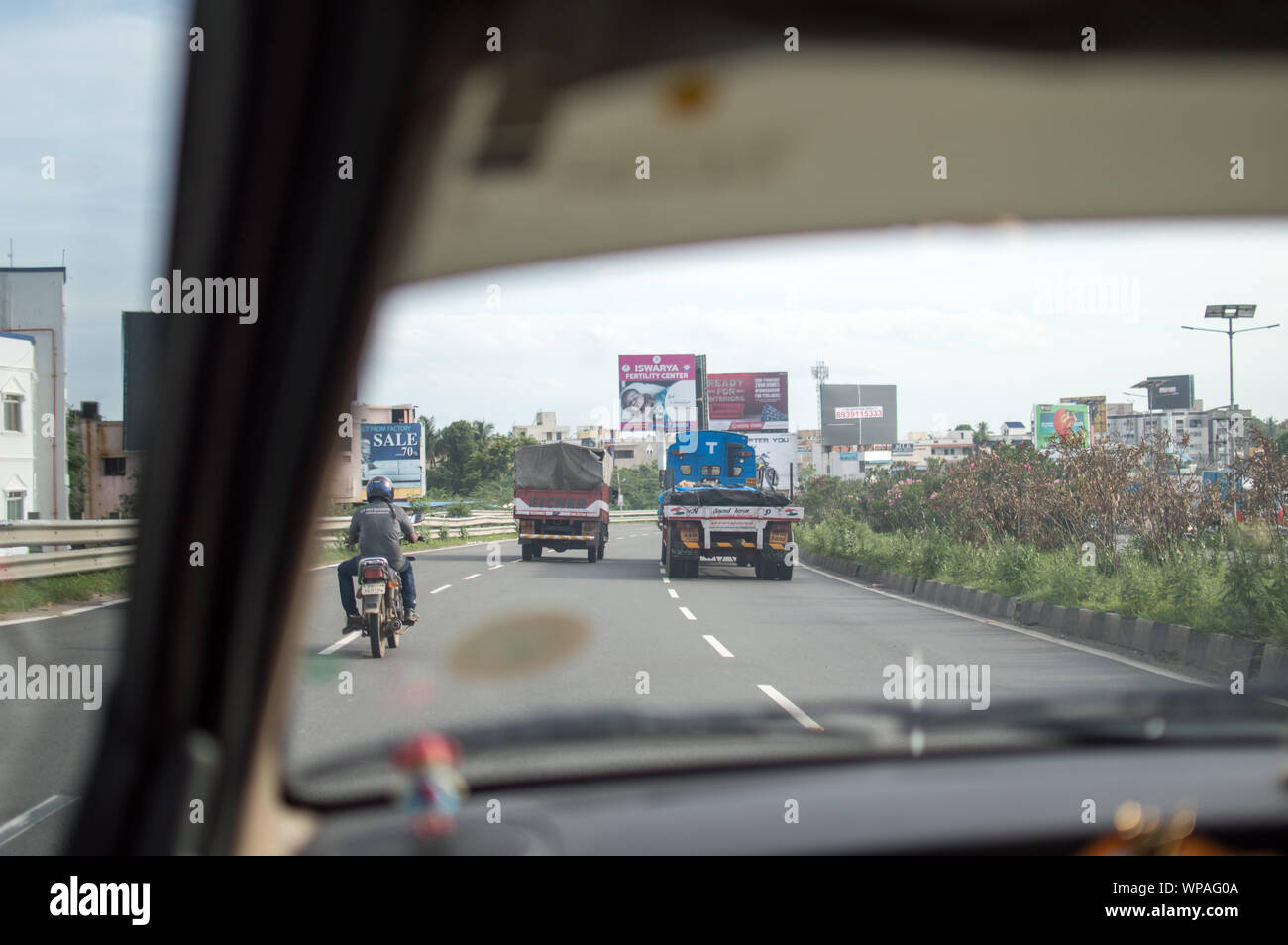 Vista di un'autostrada nazionale strada in India dal sedile passeggero anteriore di un automobile Foto Stock