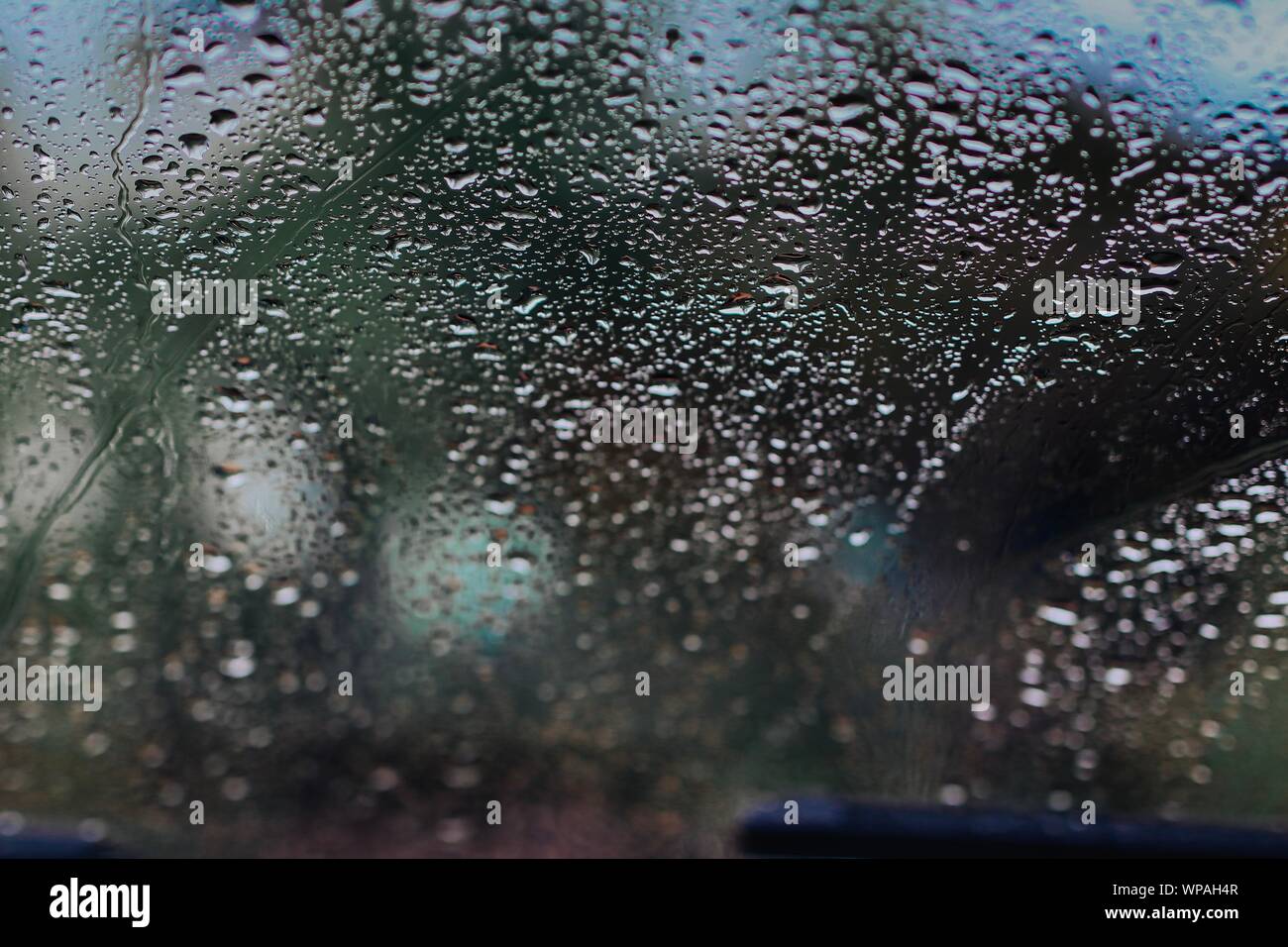 Gocce di pioggia sul vetro per auto Foto Stock