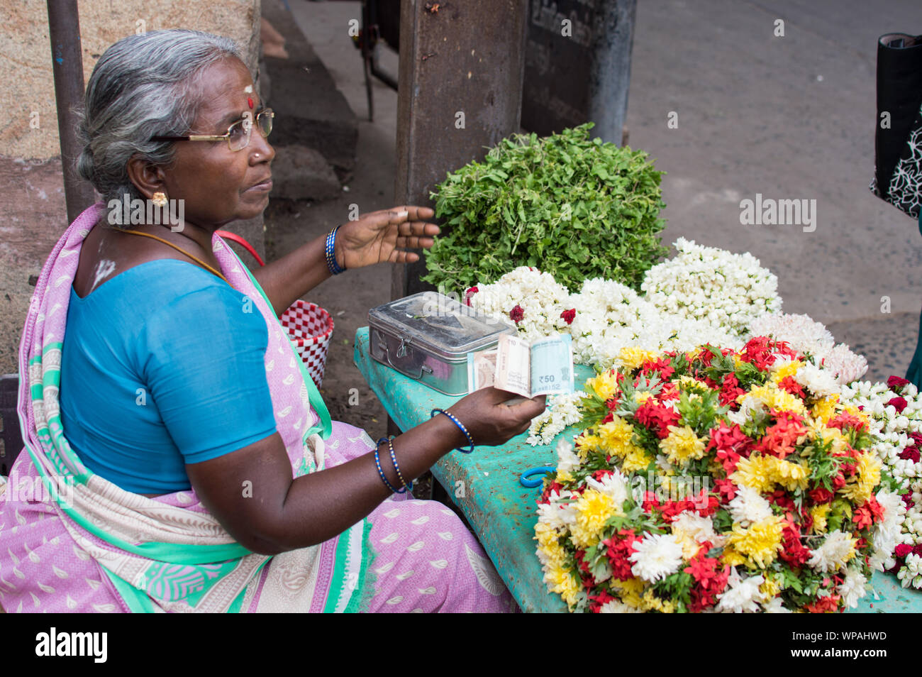 Le donne indiane che vendono fiori al di fuori del tempio di Srirangam nella città di Trichy Foto Stock
