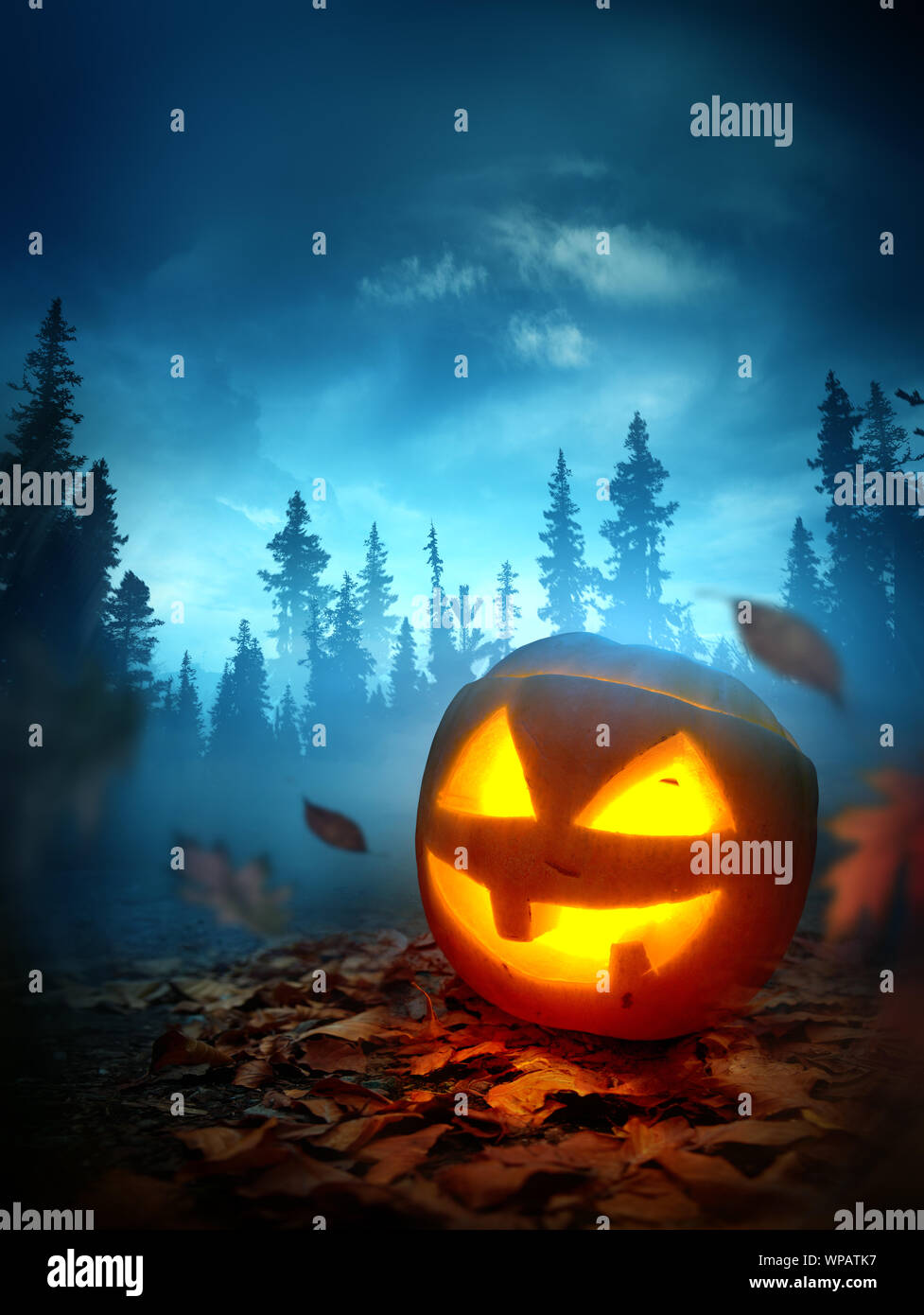Un Halloween sfondo con una rutilante spooky Jack o zucca lanterna al di fuori di notte con una foresta in background. Foto composite. Foto Stock
