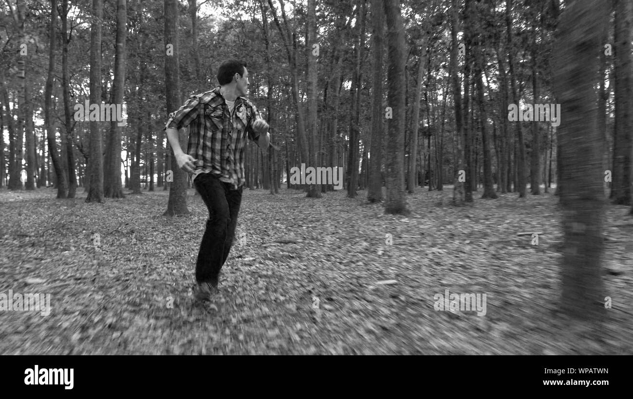 L uomo nella paura di fuggire da qualcosa nella foresta. Foto Stock