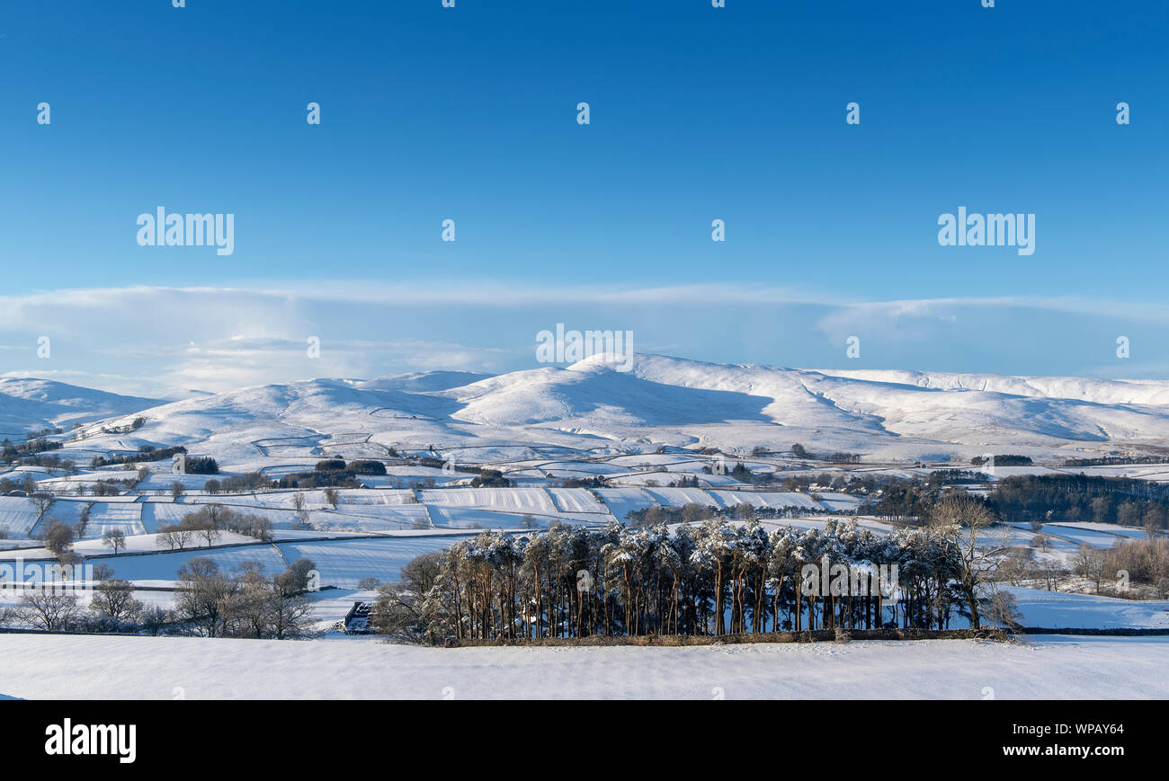 Howgill Fells ricoperta di neve dietro il villaggio di Ravenstonedale, Yorkshire Dales, Cumbria, Regno Unito. Foto Stock