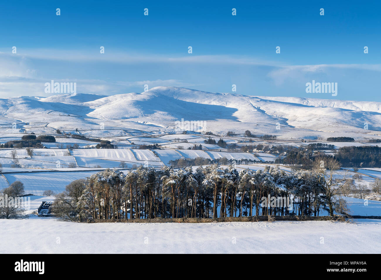 Howgill Fells ricoperta di neve dietro il villaggio di Ravenstonedale, Yorkshire Dales, Cumbria, Regno Unito. Foto Stock
