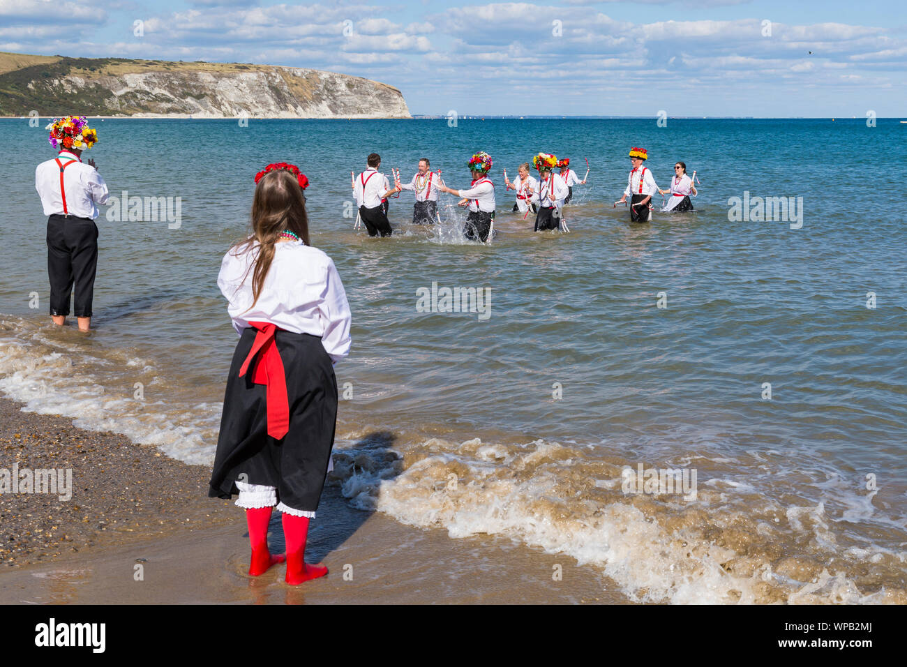 Swanage, DORSET REGNO UNITO. 8 settembre 2019. La folla affollano la città balneare di Swanage per godere della danza, con oltre 50 squadre di danza tra cui morris dancing a Swanage Folk Festival. Ballerini di Morris dance in mare al termine della due giorni del festival in un giorno caldo e soleggiato. Basingclog Morris ballerini danzare in mare. Credito: Carolyn Jenkins/Alamy Live News Foto Stock