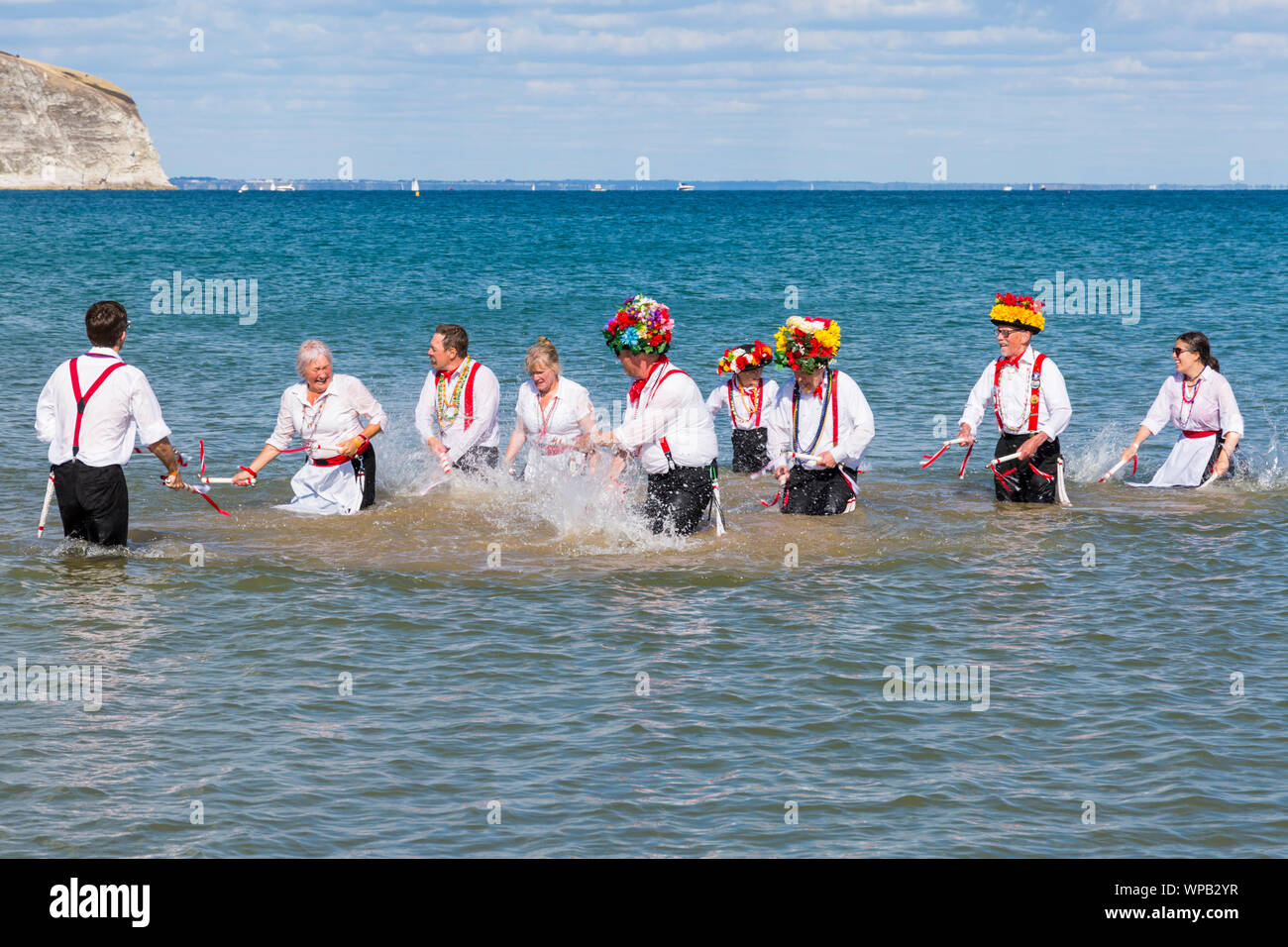 Swanage, DORSET REGNO UNITO. 8 settembre 2019. La folla affollano la città balneare di Swanage per godere della danza, con oltre 50 squadre di danza tra cui morris dancing a Swanage Folk Festival. Ballerini di Morris dance in mare al termine della due giorni del festival in un giorno caldo e soleggiato. Basingclog Morris ballerini danzare in mare. Credito: Carolyn Jenkins/Alamy Live News Foto Stock