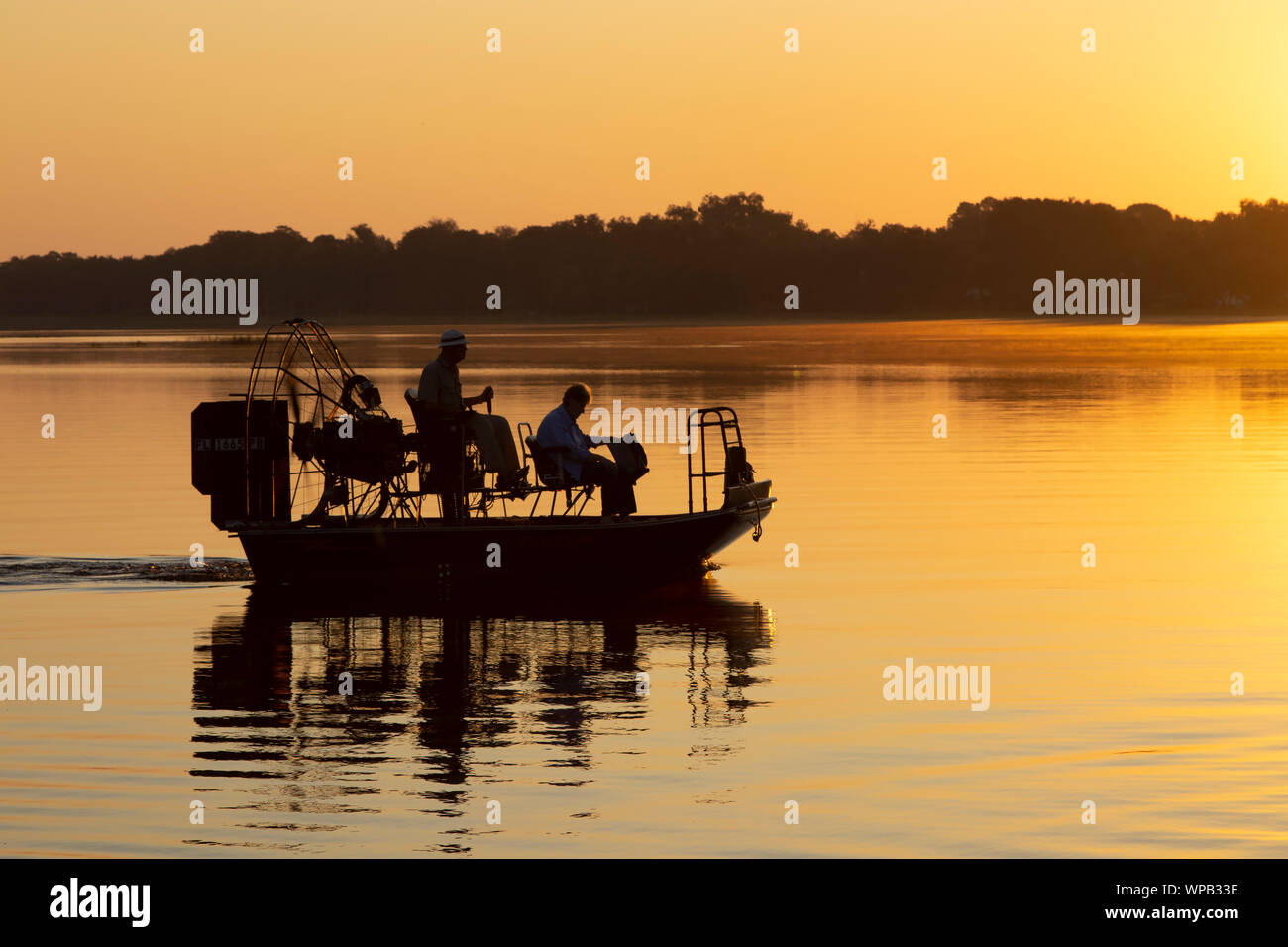 I pescatori escono in un airboat all alba di un giorno di avventura in un lago della Florida. Foto Stock