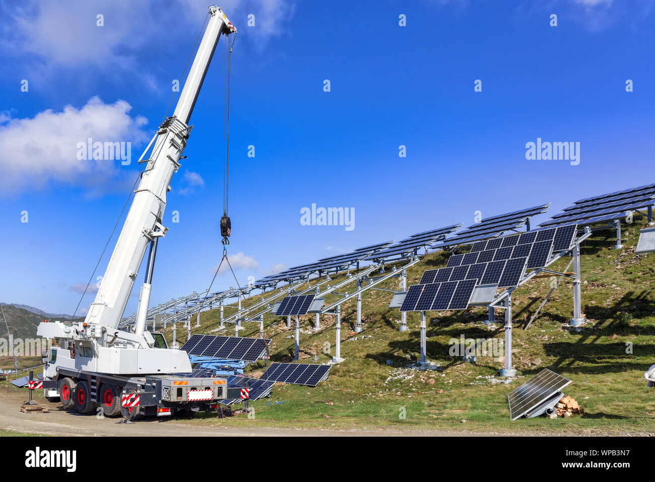 Il lavoratore professionale di installare pannelli solari sul verde della costruzione metallica. Soluzione innovativa per energia a risolvere. Utilizzare le risorse rinnovabili. Green IT Foto Stock