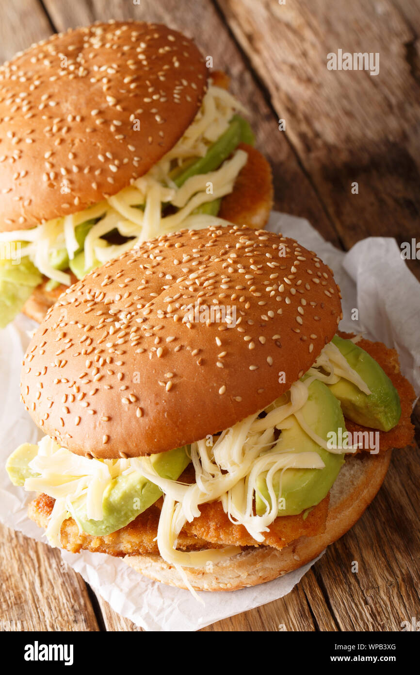 Il Messico di morbidissima cemita poblana trabocca di queso blanco, chipotle, pepe, avocado, papalo e fritto croccante cotoletta di close-up sul piano verticale. Foto Stock