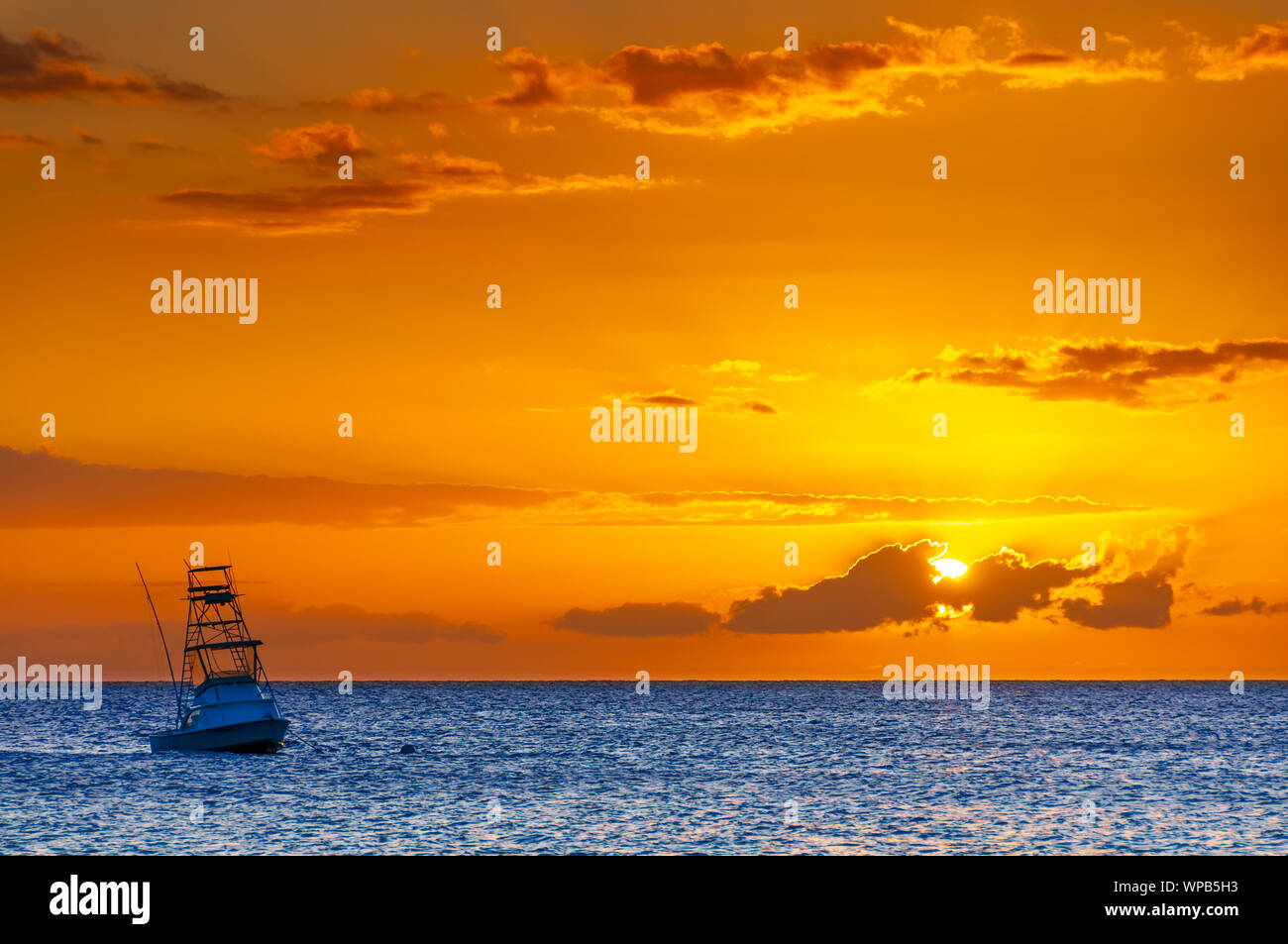 Bel tramonto dietro lo sport barca da pesca con un flying bridge a Maui, Hawaii, STATI UNITI D'AMERICA Foto Stock