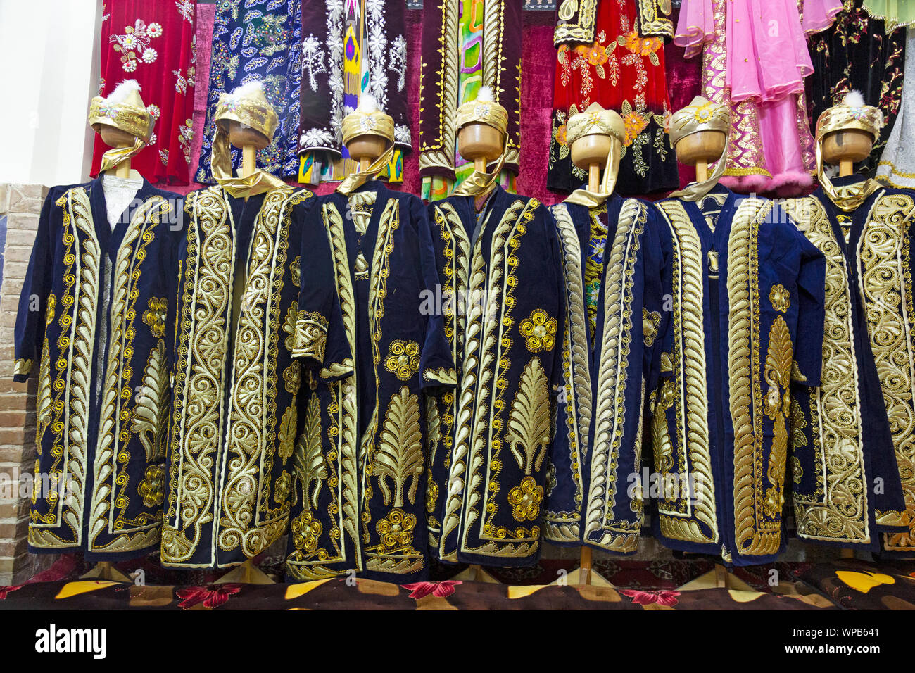 Tradizionale costume uzbeko essendo venduto in un negozio in Samarcanda, Uzbekistan. Foto Stock