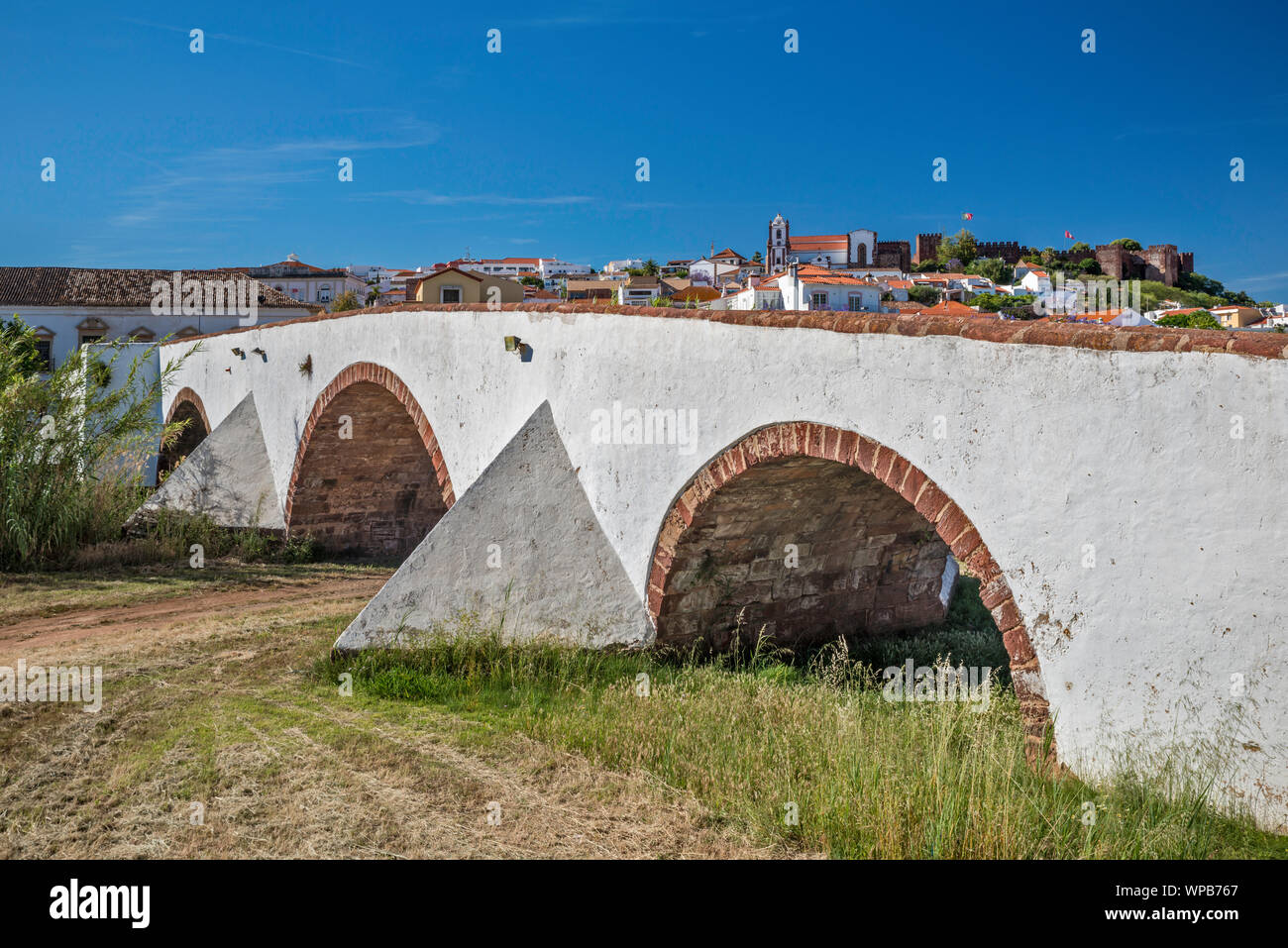 Ponte romano sul Rio Arado, in distanza castello moresco e la cattedrale della città di Silves, distretto di Faro, Algarve, PORTOGALLO Foto Stock