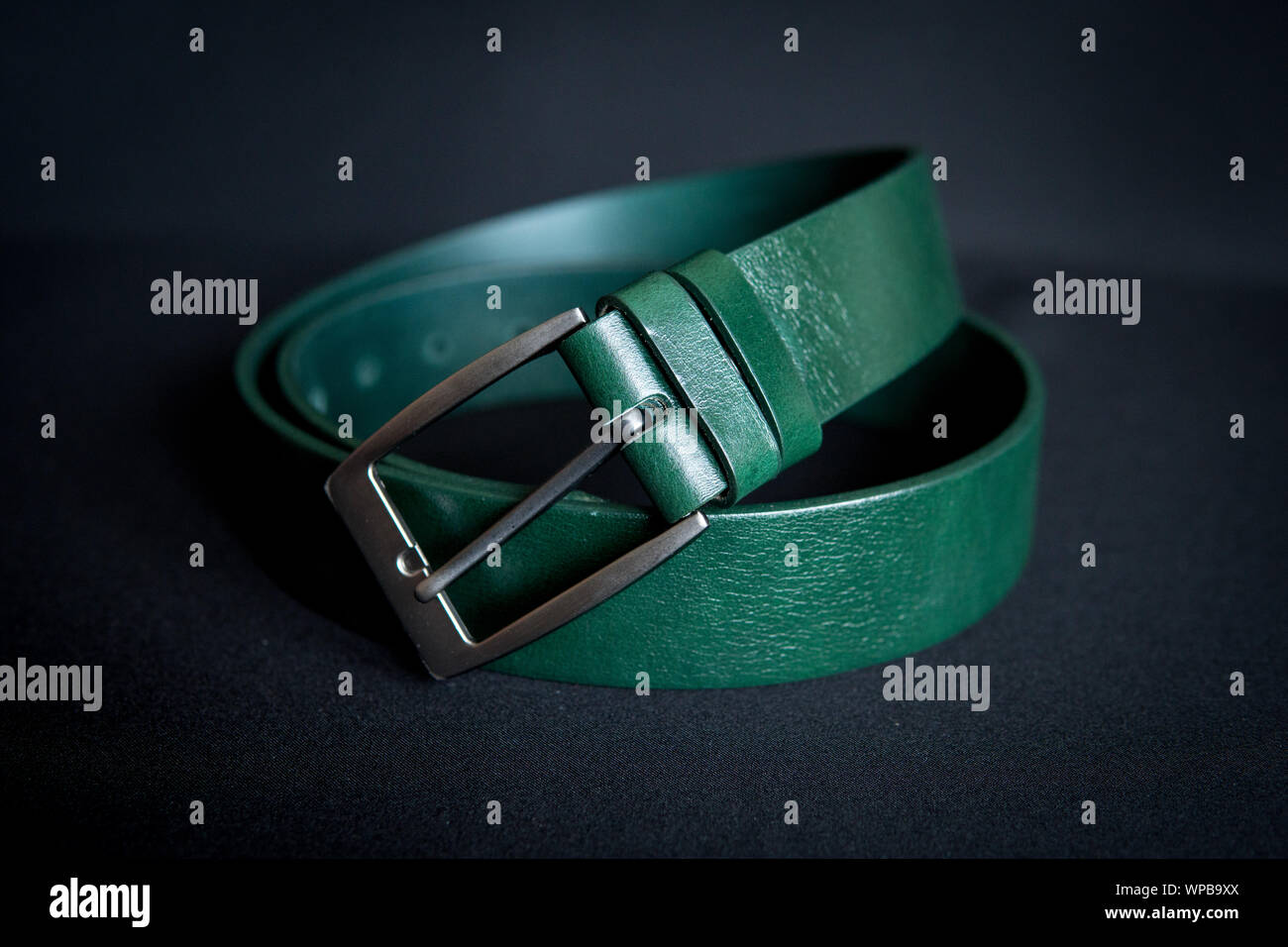 Dettaglio di uomini la cintura verde di isolate su sfondo nero Foto Stock