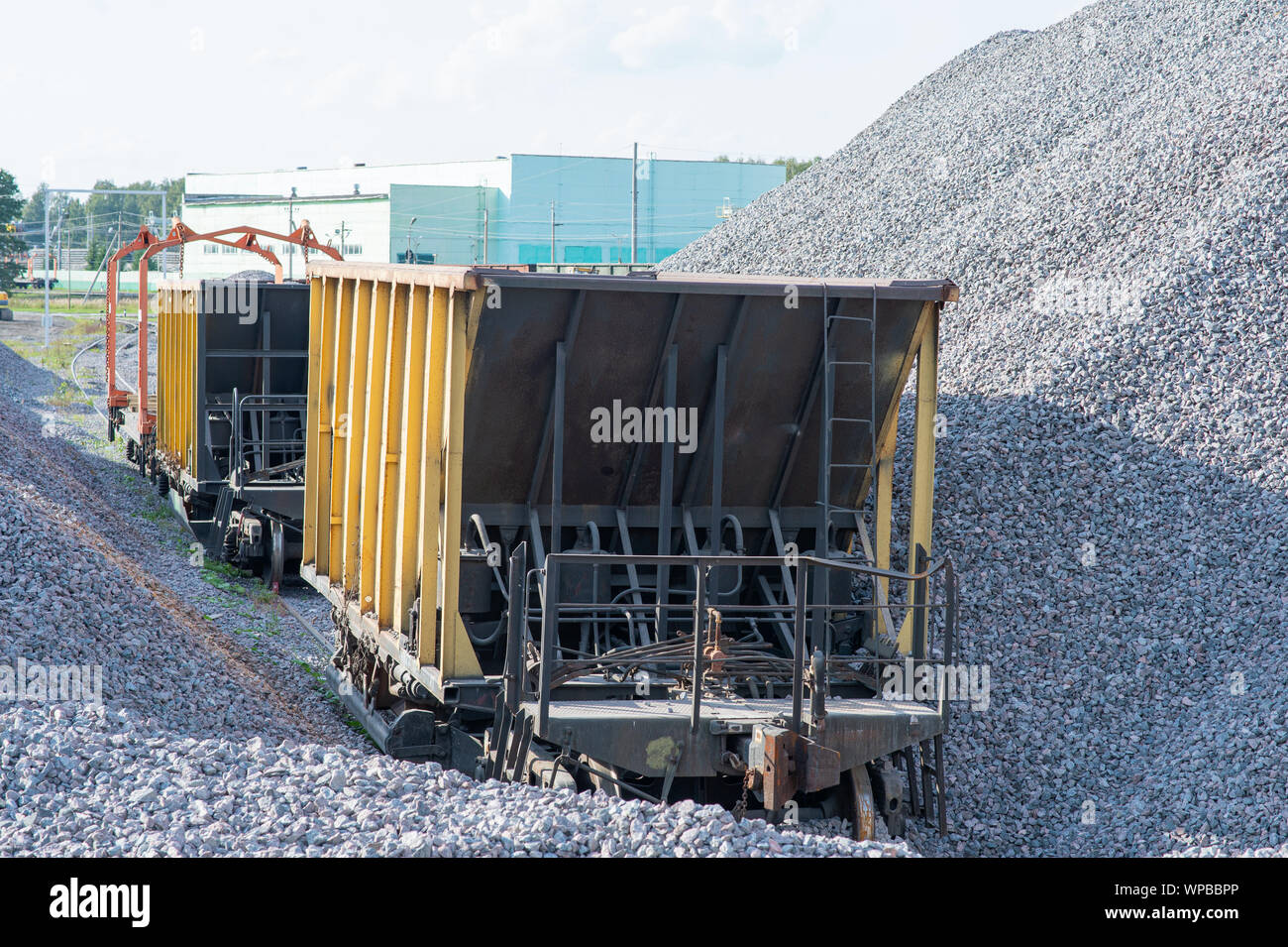 Il trasporto ferroviario sul carico con pietrisco. Il trasporto di materiali alla rinfusa. binario ferroviario di manutenzione. Foto Stock