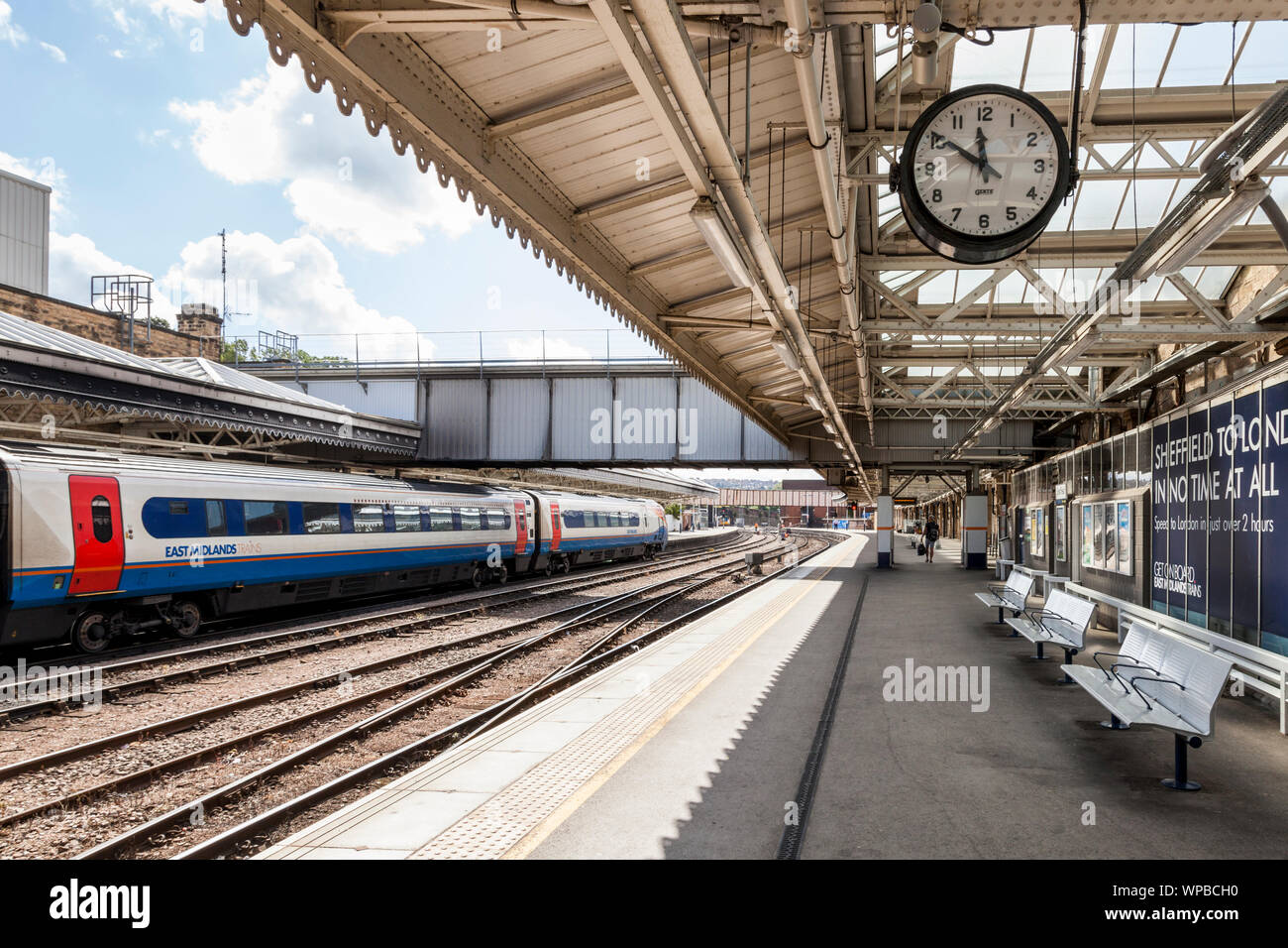 Quasi vuota stazione ferroviaria piattaforma con il vecchio stile orologio, e treno su altre piattaforme, Sheffield stazione ferroviaria, Sheffield, Yorkshire, Inghilterra, Regno Unito Foto Stock