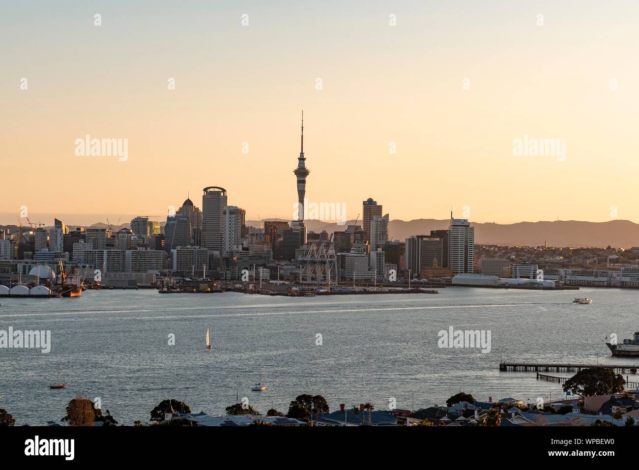 Skyline di Auckland al tramonto, Waitemata Harbour, Sky Tower, il quartiere centrale degli affari di Auckland, Isola del nord, Nuova Zelanda Foto Stock