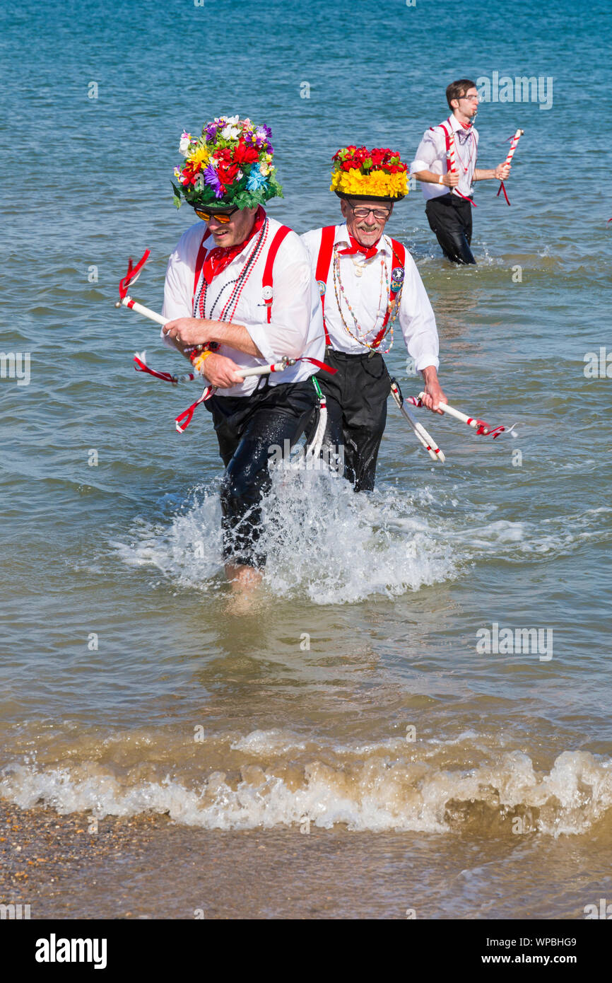 Swanage, DORSET REGNO UNITO. 8 settembre 2019. La folla affollano la città balneare di Swanage per godere della danza, con oltre 50 squadre di danza tra cui morris dancing a Swanage Folk Festival. Ballerini di Morris dance in mare al termine della due giorni del festival in un giorno caldo e soleggiato. Basingclog Morris ballerini danzare in mare. Credito: Carolyn Jenkins/Alamy Live News Foto Stock