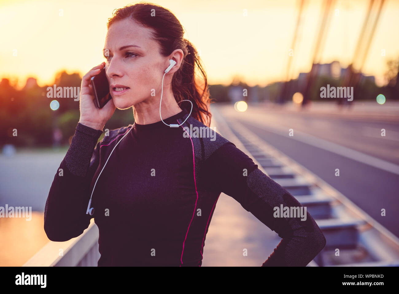Donna Fitness parlando su smart phone e il riposo dopo l'esecuzione Foto Stock Donna Fitness parlando su smart phone e il riposo dopo l'esecuzione Foto Stock