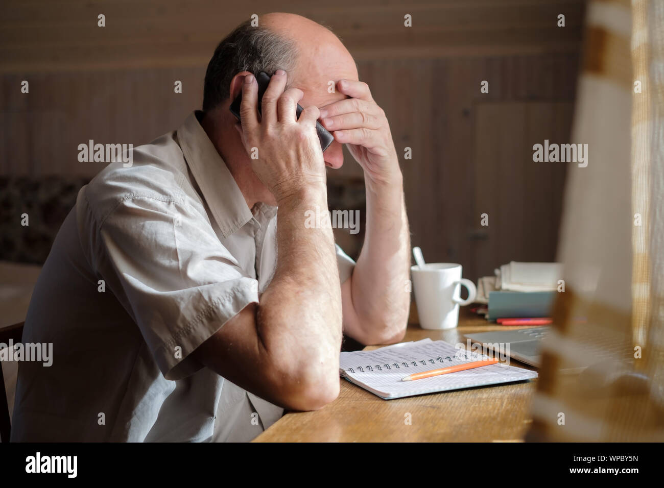 Senior uomo sensazione sconvolto avente conversazione telefonica premuta da audizione cattive notizie seduti a casa Foto Stock