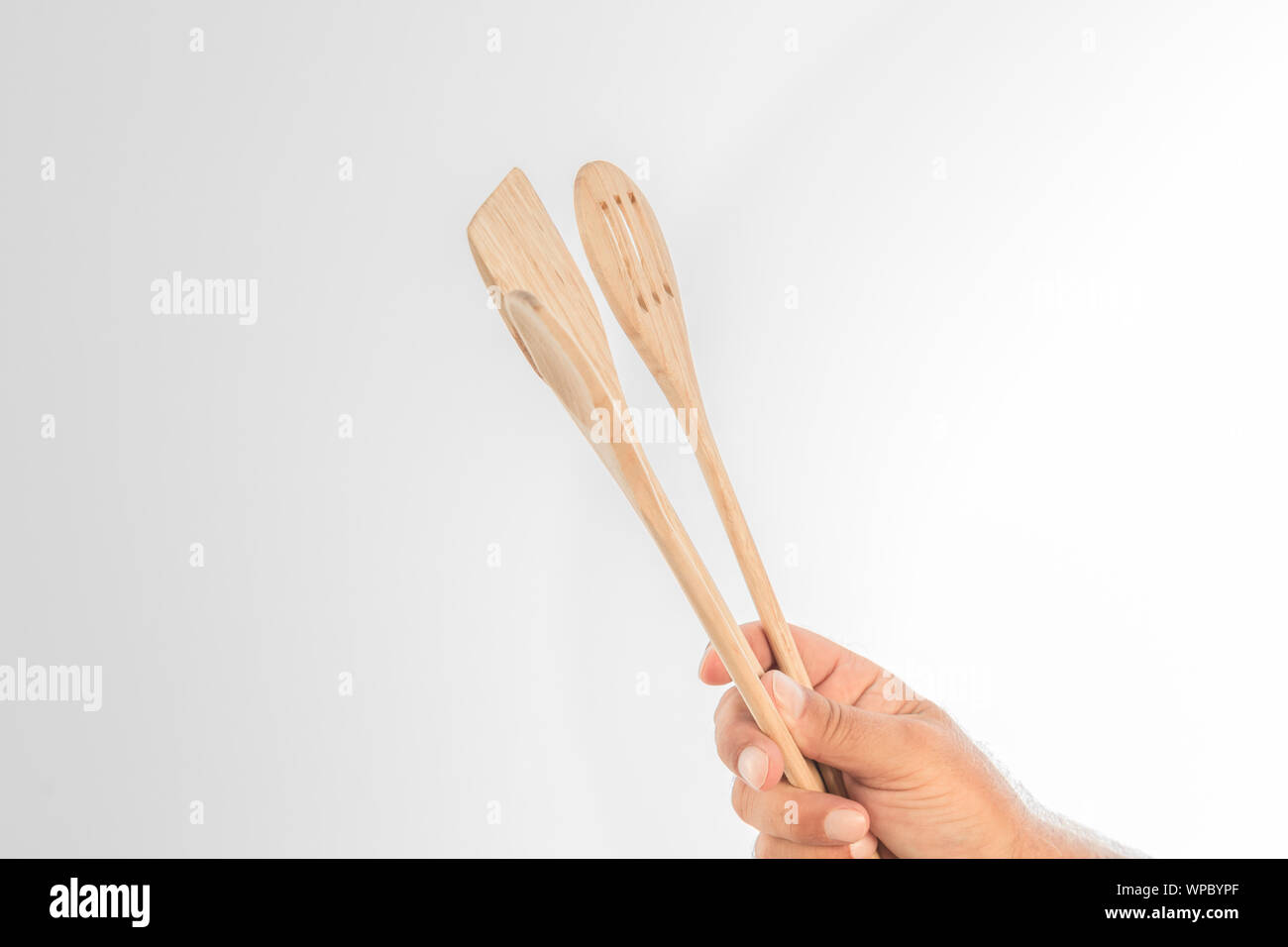 Legno due mestoli detenute da un lato su uno sfondo bianco. Foto Stock
