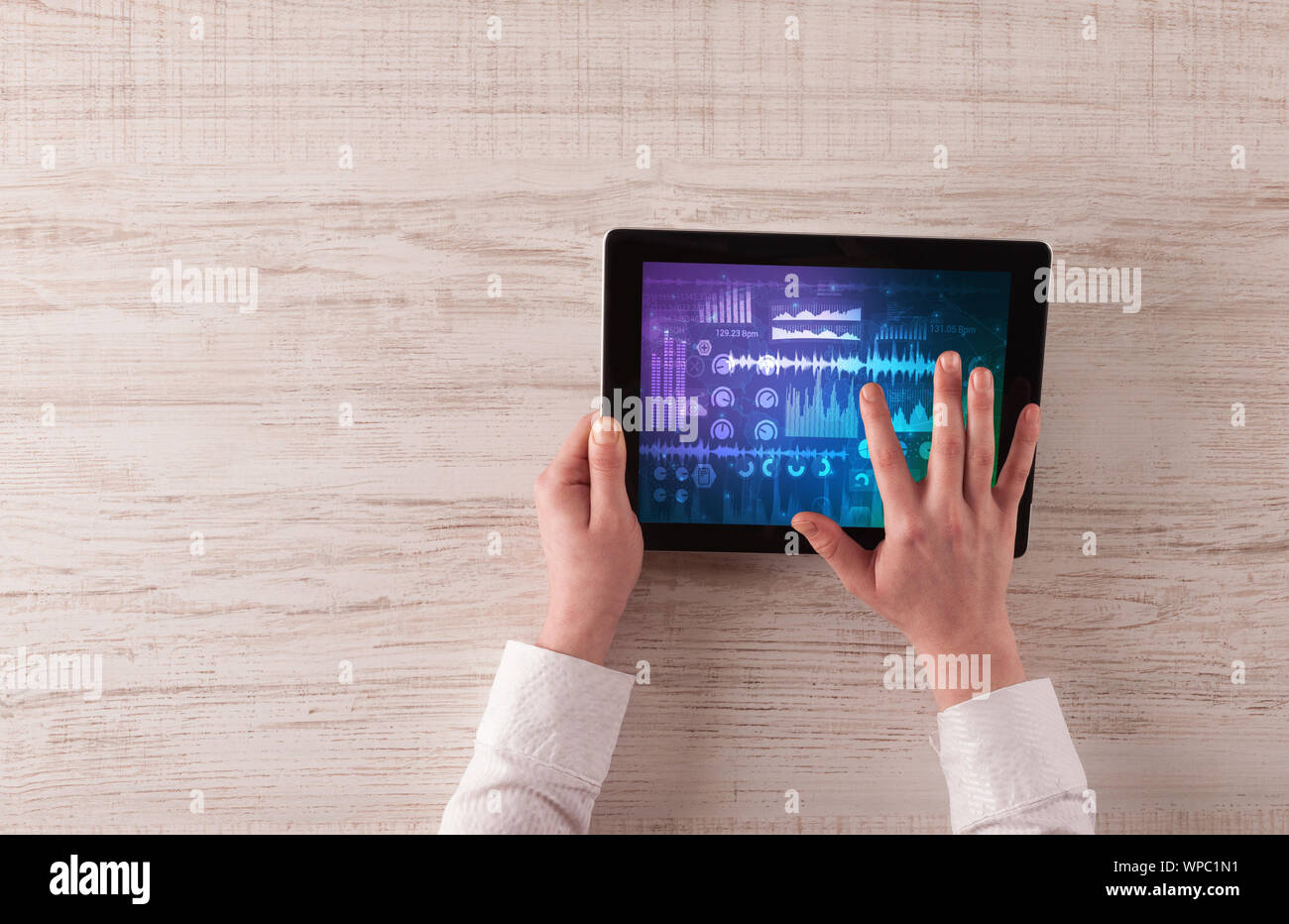 Mano toccando tablet con forme d'onda e sound design concept Foto Stock