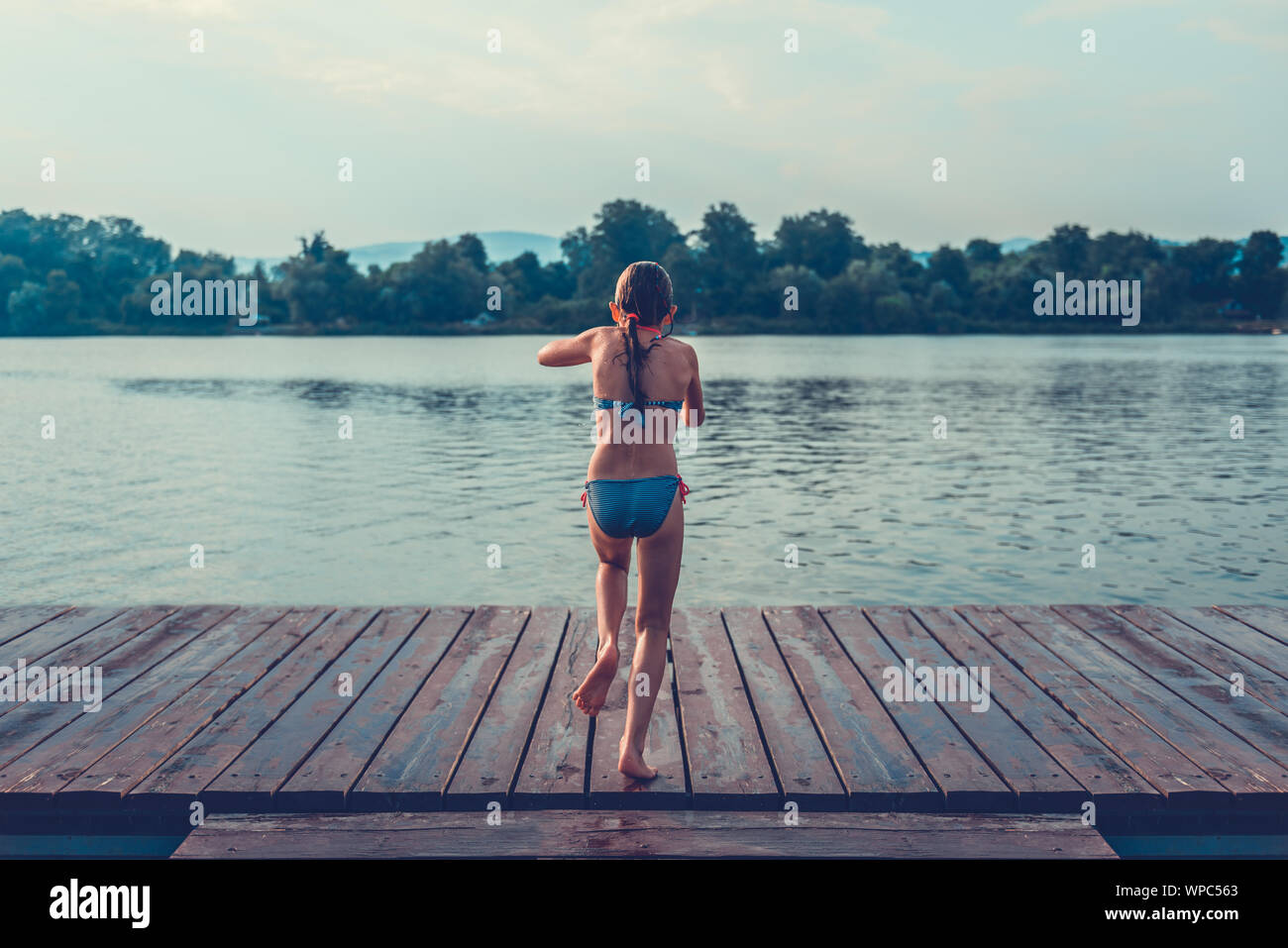 Ragazza saltando in acqua dal dock Foto Stock Ragazza saltando in acqua dal dock Foto Stock