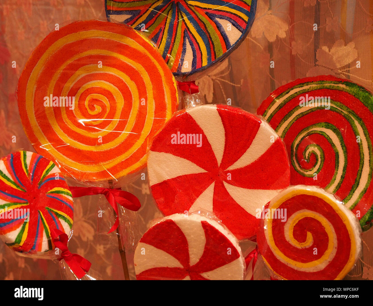 Vivacemente colorato imitazione whirlygig lecca-lecca dolci in involucri di cellophane in corrispondenza di un visualizzatore in Cumbria,l'Inghilterra,UK Foto Stock