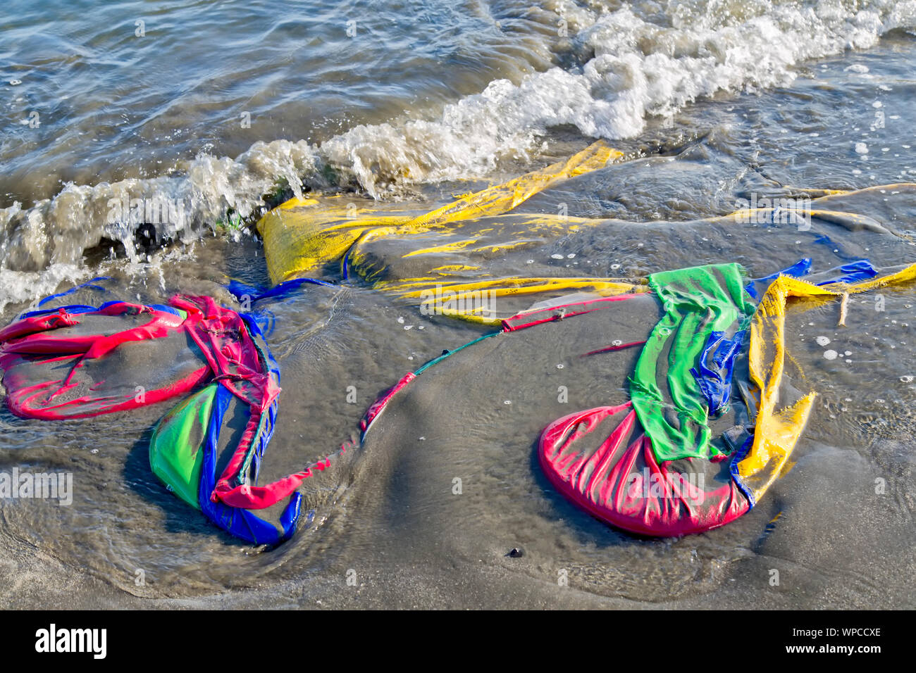 Marea depositato di poliestere colorato tenda, spiaggia costiera. Foto Stock
