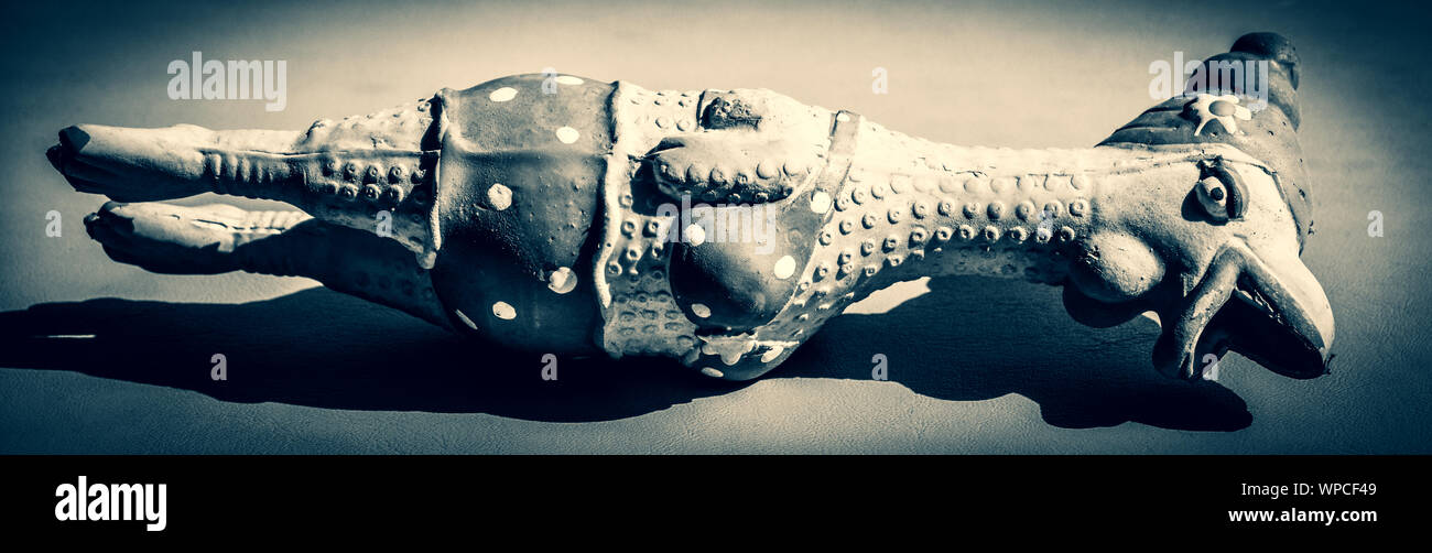 Una vista panaromic inatteso di un lattice di pollo pizzicata cane giocattolo squeeze indossando il rossetto e bikini che stabilisce nel sole, in tono di selenio Foto Stock