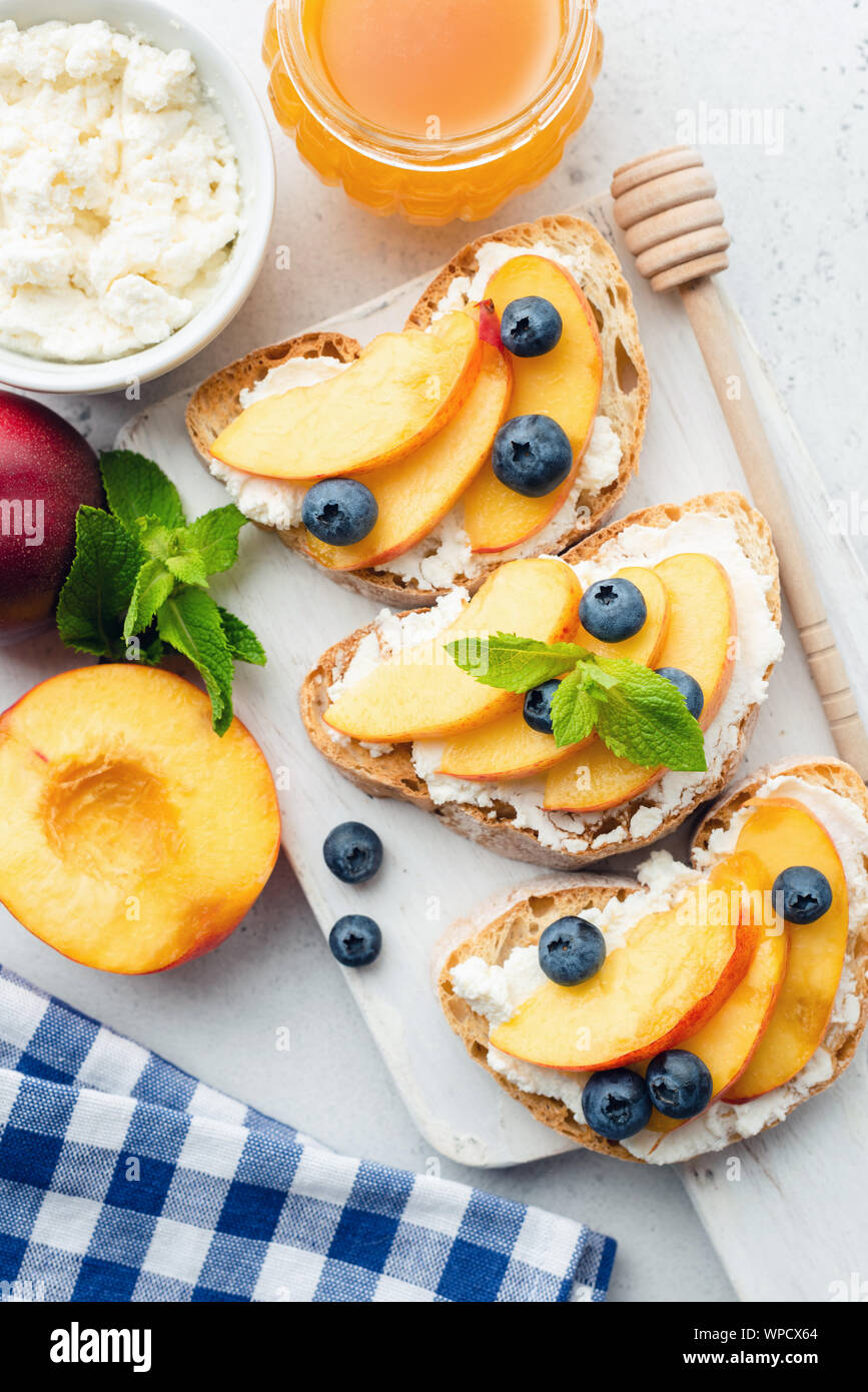 Frutti dolci bruschetta con ricotta, miele e pesca in legno bianco che  serve vassoio. Vista superiore Foto stock - Alamy