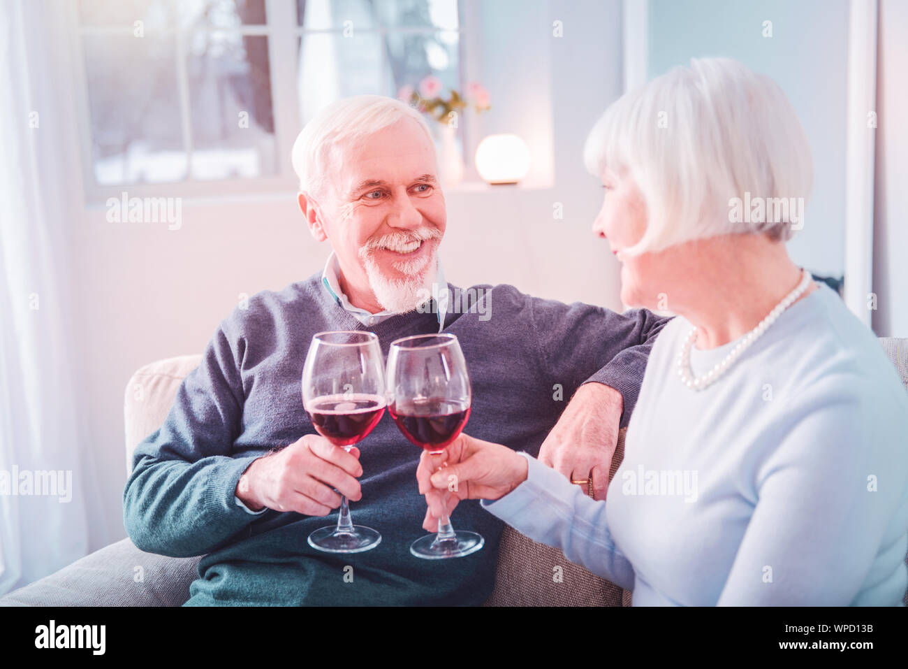 Coppia di trasmissione via IR di pensionati cembalo che loro bicchieri avente una cena romantica Foto Stock