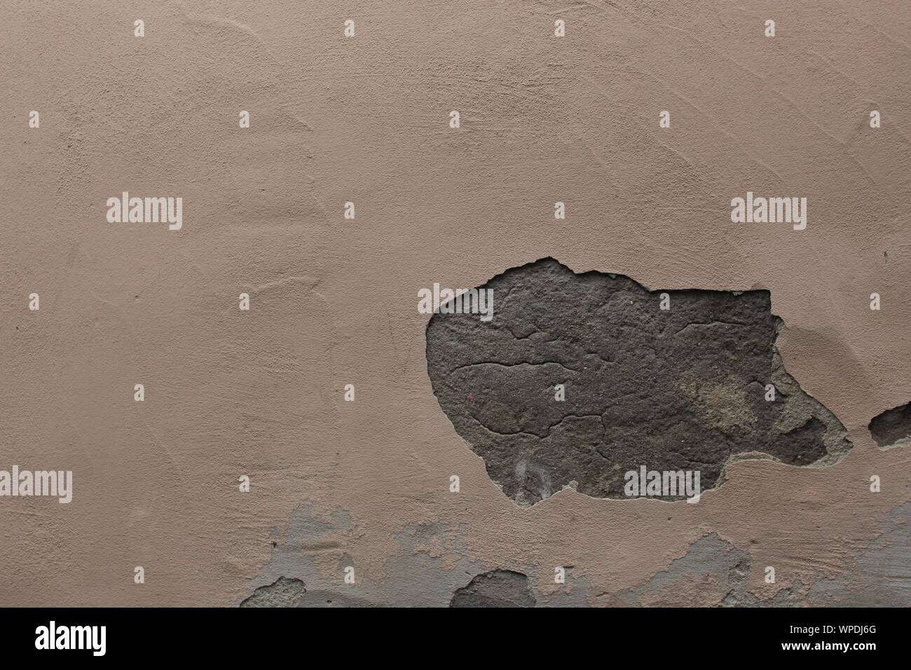 Il vecchio muro beige con un foro in gesso Foto Stock