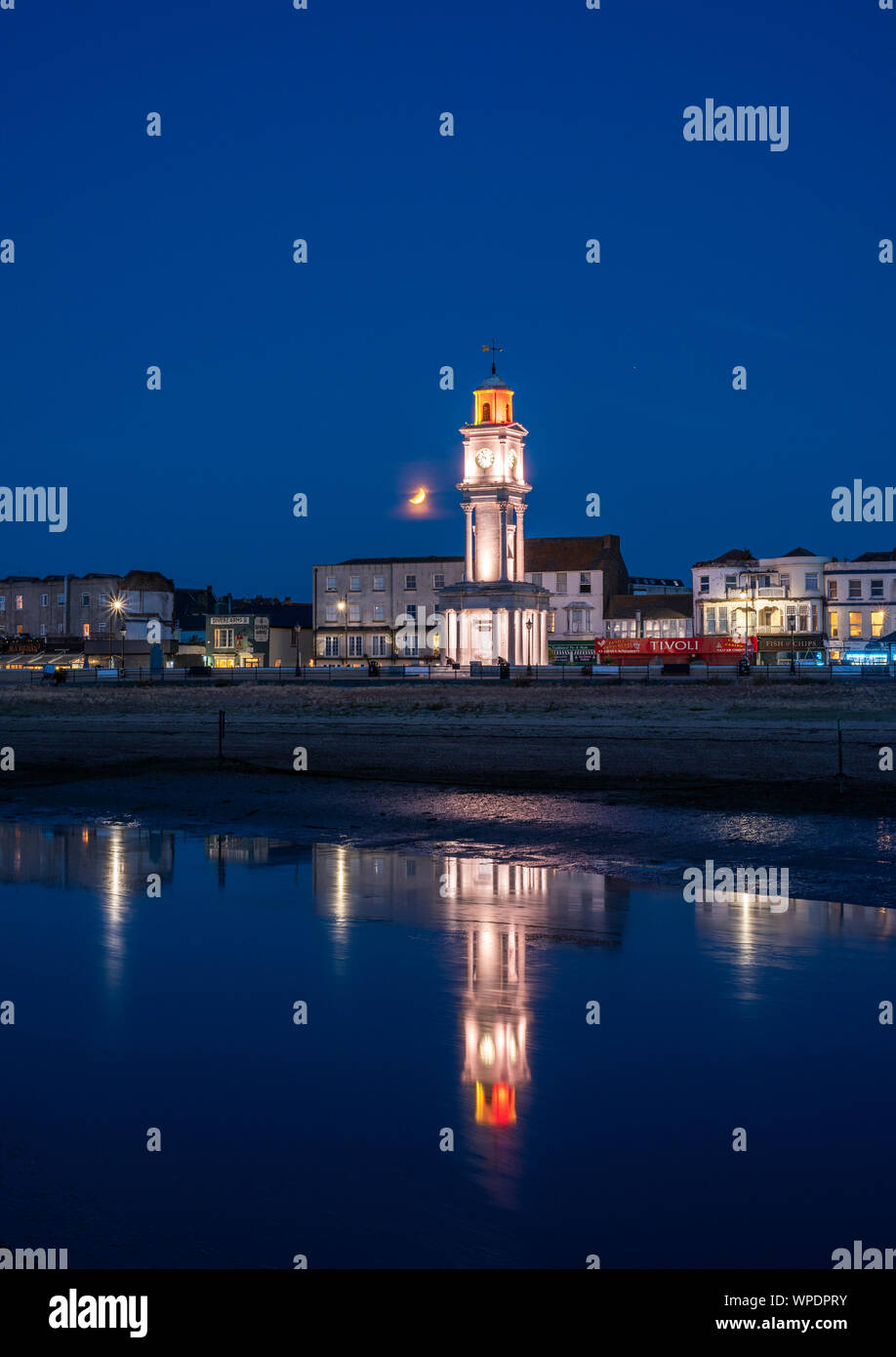 Il 2019 Eclissi lunare parziale assistito a Herne Bay torre dell orologio su alla costa del Kent. Foto Stock