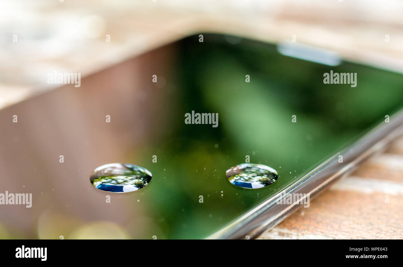 Smartphone con gocce di acqua come un segno di acqua danni Foto Stock