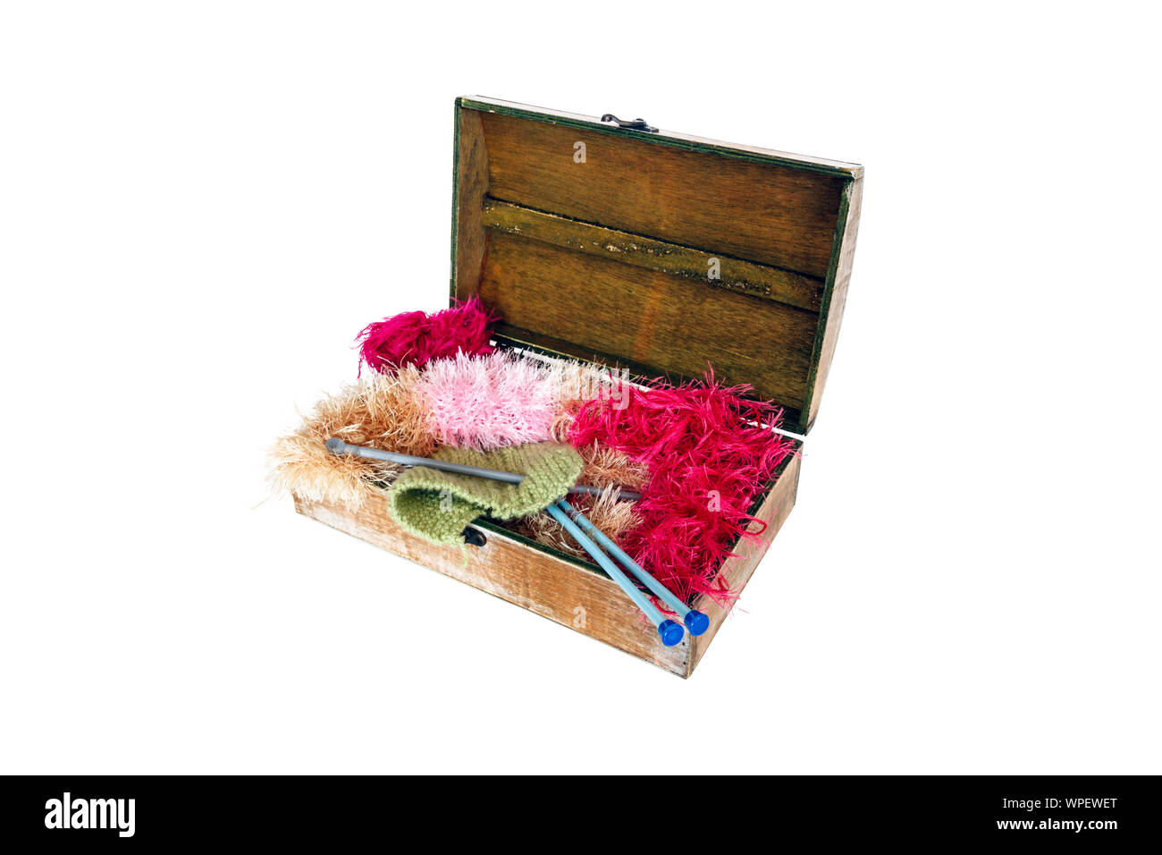 Un artigianato in legno scatola contenente maglia, aghi, soffici e filati di lana, isolato su uno sfondo bianco Foto Stock