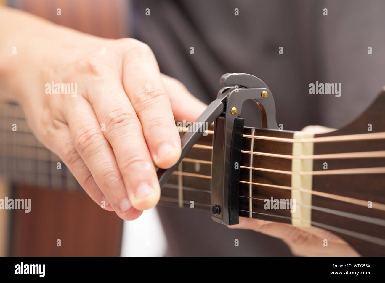 Close up-Le mani sono la regolazione del capo per regolare il suono della chitarra. Foto Stock