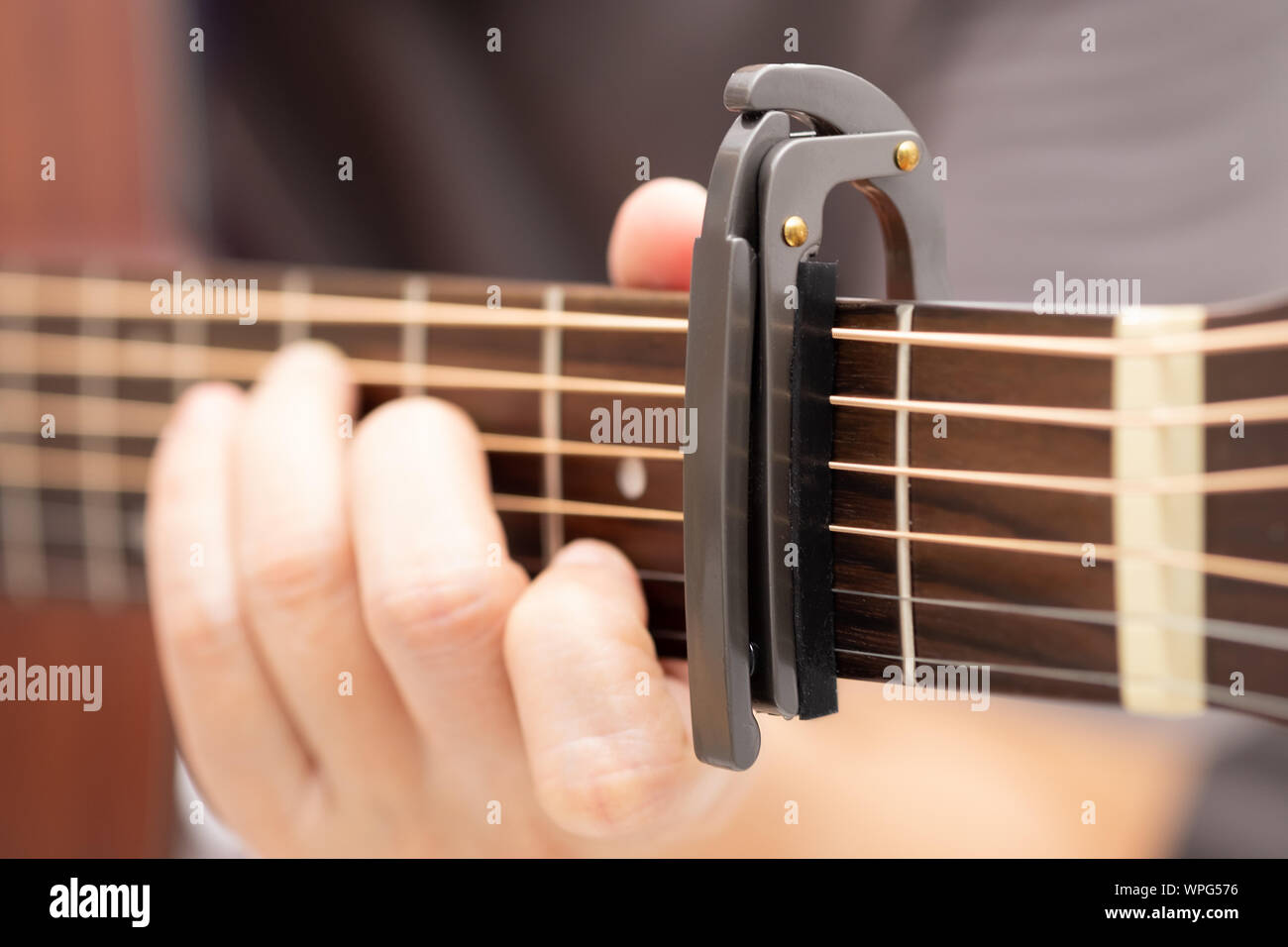 Close up-Le mani sono la regolazione del capo per regolare il suono della chitarra. Foto Stock
