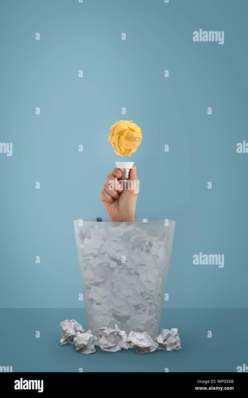 Idea con palla di carta e lampadina della donna è apparso a mano dal cestino. Attività creativa del concetto. Foto Stock