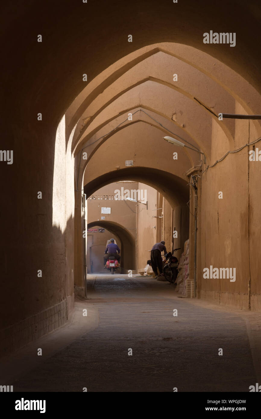 YAZD, IRAN - Ottobre 2, 2017: due abitanti in un vicolo arcuata nel centro storico della città deserta Yazd, Iran. Famosa per il suo adobe (mattone di fango) Foto Stock YAZD, IRAN - Ottobre 2, 2017: due abitanti in un vicolo arcuata nel centro storico della città deserta Yazd, Iran. Famosa per il suo adobe (mattone di fango) Foto Stock