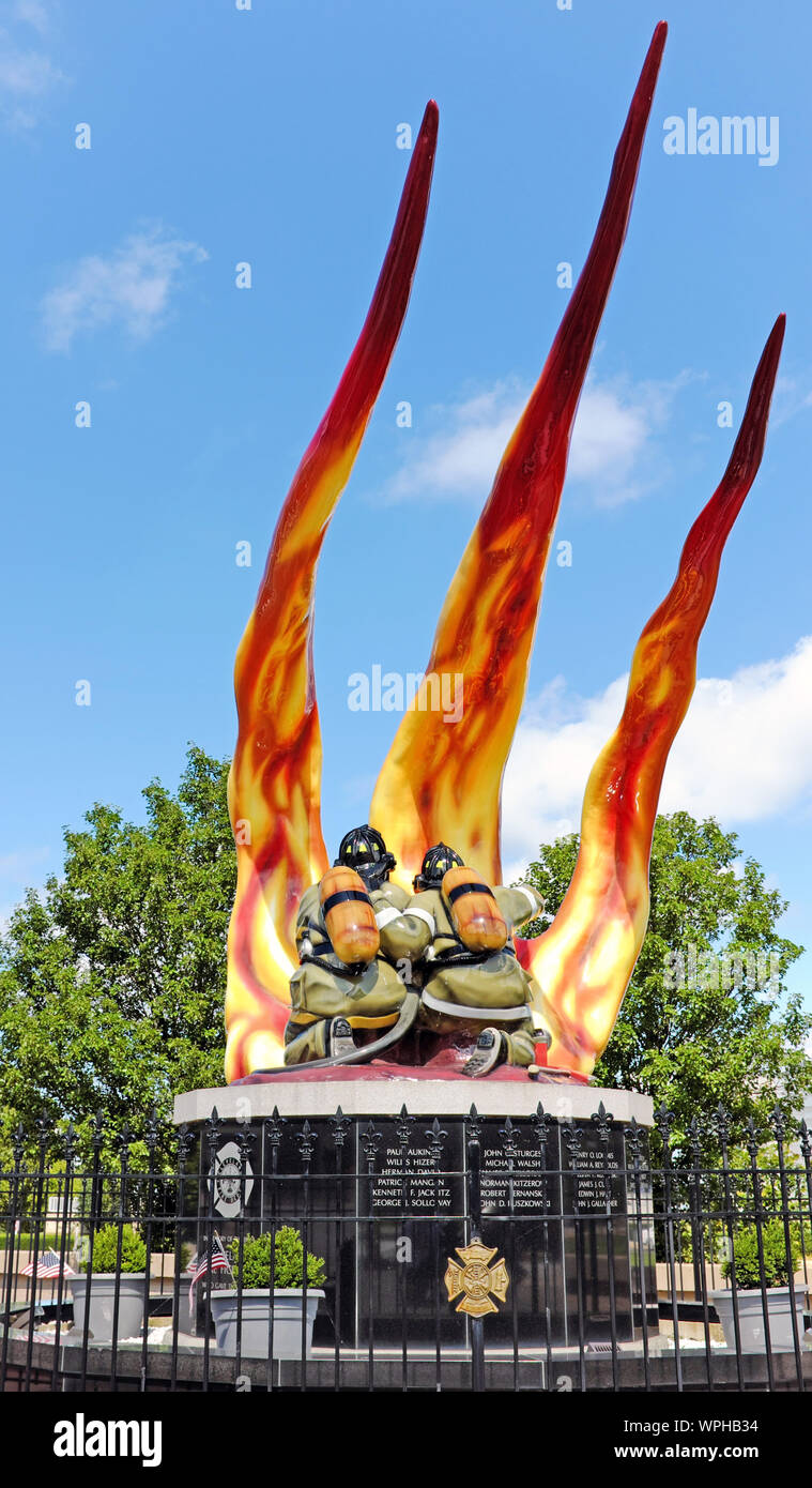 Due vigili del fuoco combattono un colpo nel Cleveland Firefighter Memorial, una scultura in vetroresina che onora coloro che sono morti nella linea di servizio a Cleveland. Foto Stock