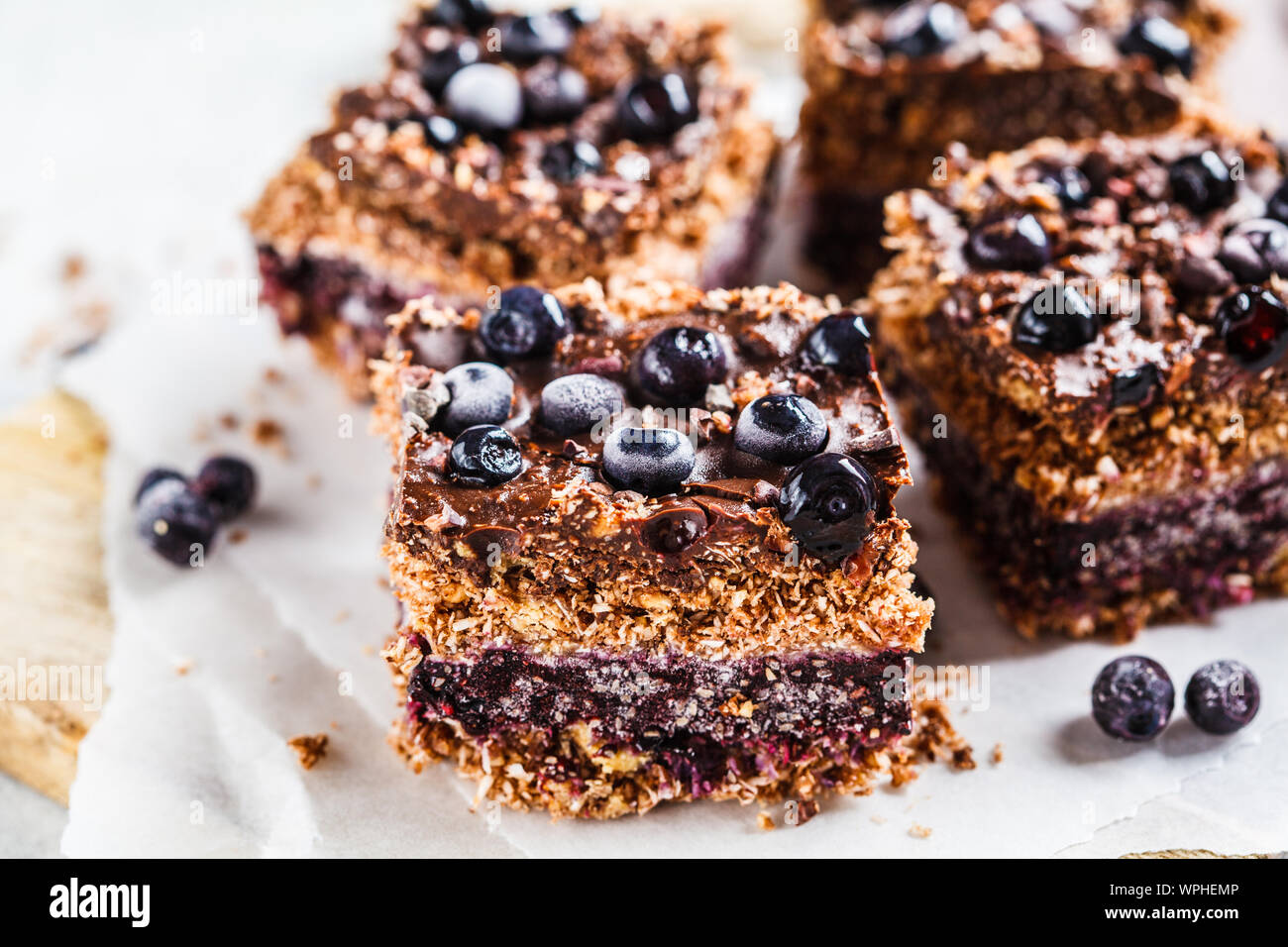 Materie vegano dessert di noce di cocco con mirtilli sulla scheda. Sano cibo vegan concetto. Foto Stock