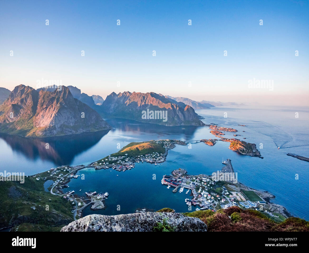 Uno splendido scenario di Reine sulla sommità del Reinebringen durante il tramonto in una limpida giornata estiva, Isole Lofoten, a nord della Norvegia Foto Stock