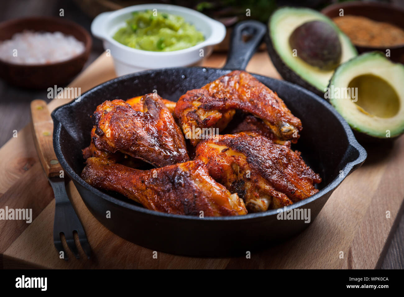 Grigliata di caldo e ali di pollo piccanti con spezie su sfondo scuro Foto Stock