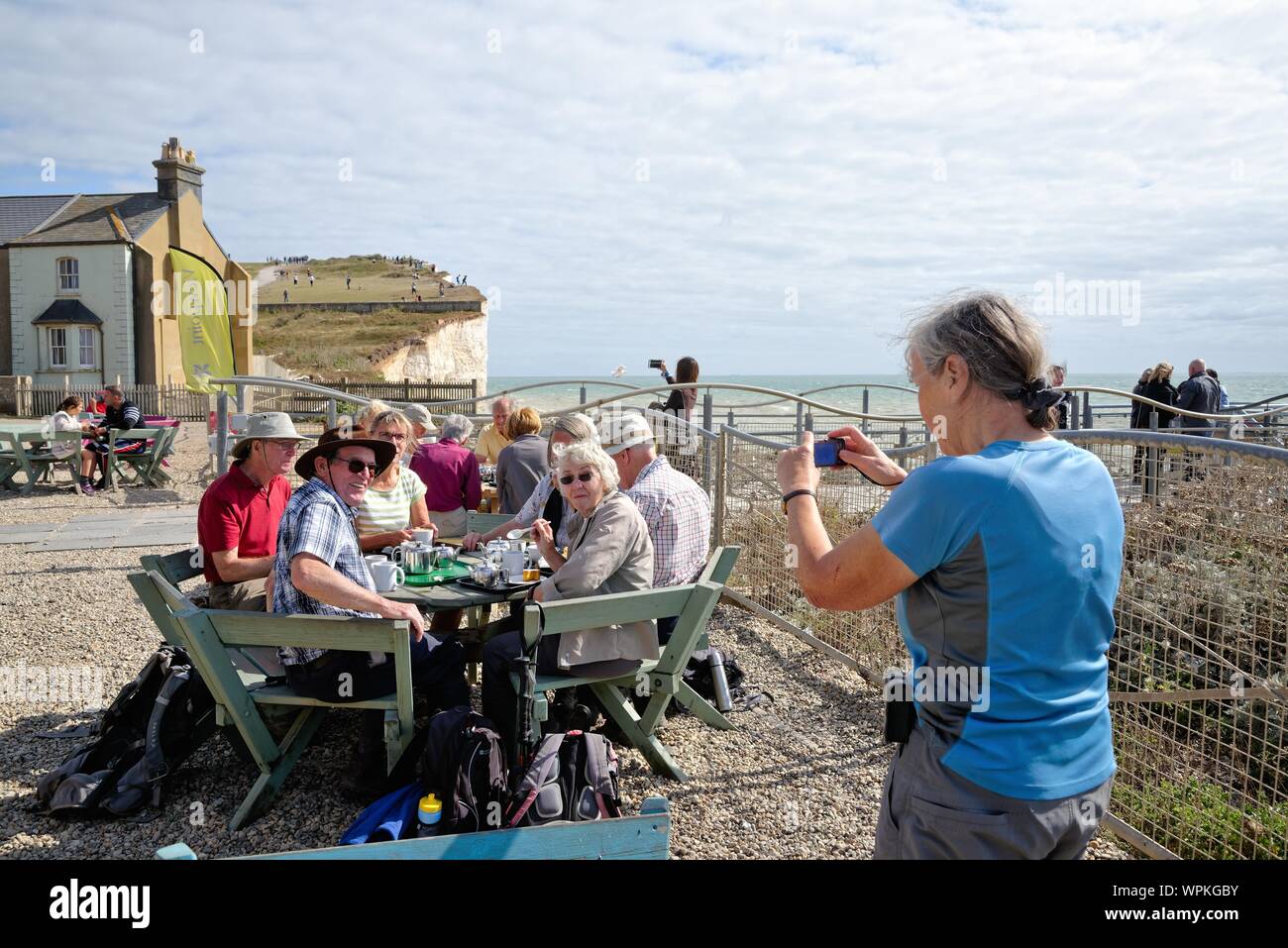 Un gruppo di anziani ramblers fotografato mentre godendo di tè e dolci sulla rupe cafe a Birling Gap East Sussex England Regno Unito Foto Stock