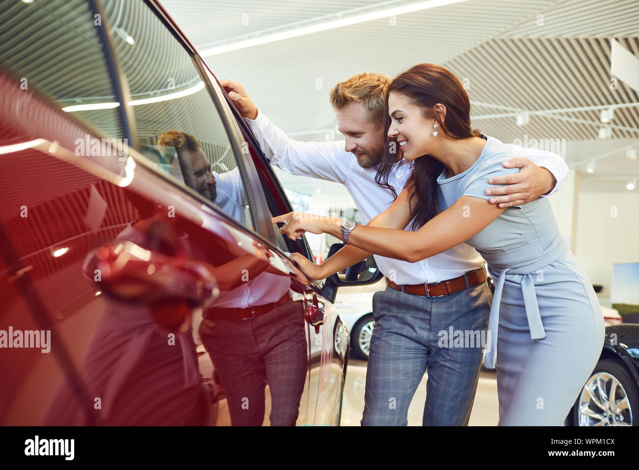 Coppia giovane scegliere una nuova auto in showroom. Foto Stock