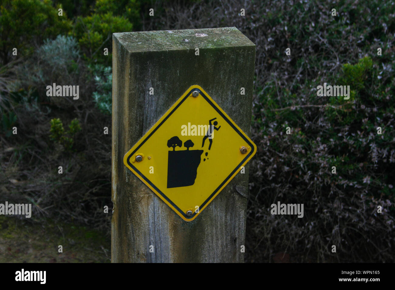 Cliff caduta segno di avvertimento a Great Ocean Road, Victoria, Australia, segnaletica di pericolo Foto Stock