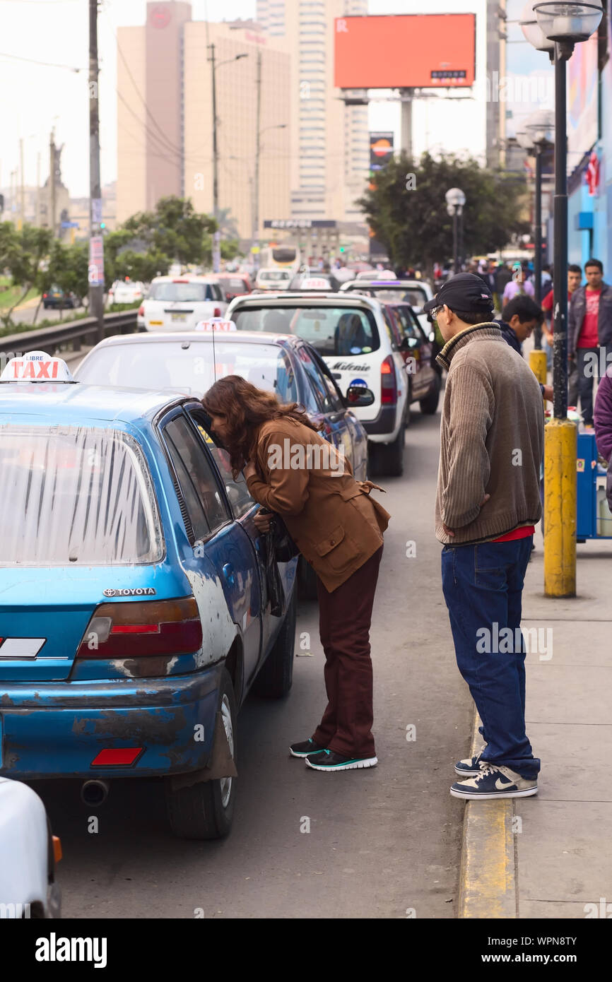 LIMA, Perù - Luglio 21, 2013: donna non identificato per chiedere un taxi per la tariffa di fronte al centro commerciale Polvos Azules su Av. Paseo de la Republica Foto Stock