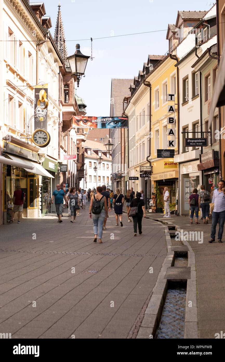 Gli amanti dello shopping camminano sulla strada pedonale di Rathausgasse a Friburgo in Breisgau, Germania. Foto Stock