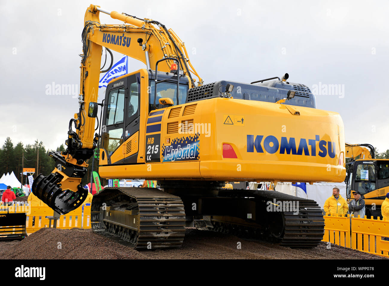 Hyvinkää, Finlandia. Il 6 settembre 2019. Komatsu HB 215 LC escavatore ibrido operatore mostra grande precisione scegliendo pack di carte con la benna a gancio. Foto Stock