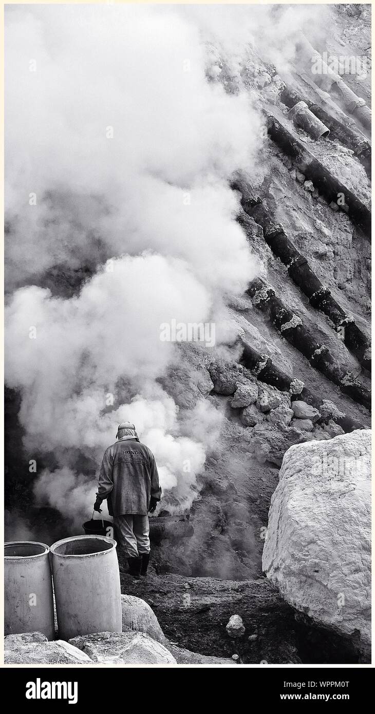 Il minatore di estratto di zolfo puro dal cratere vulcanico Foto Stock