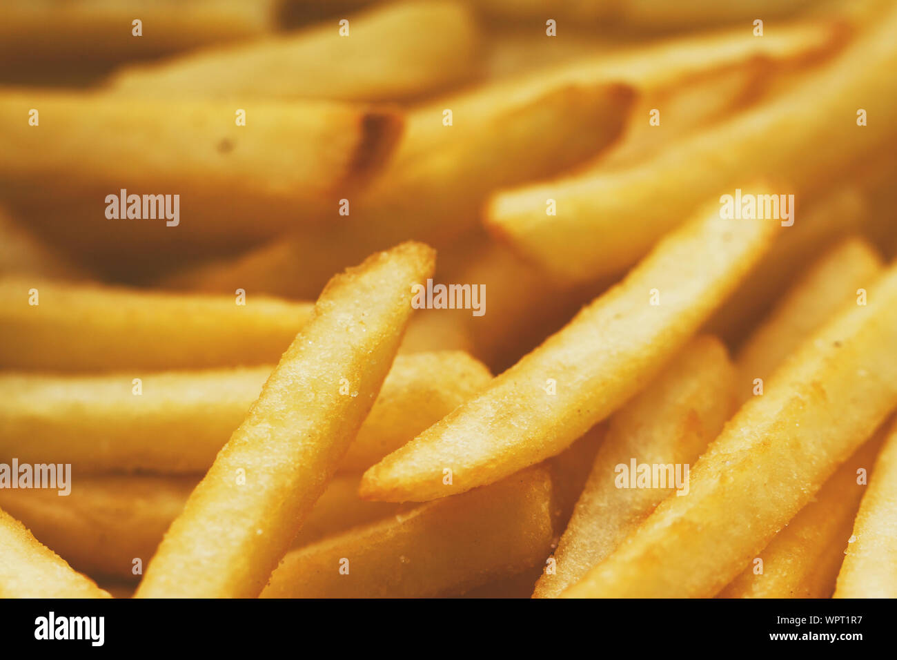 Patate fritte close up. Soluzione satura di colore giallo oro. Esso può essere utilizzato come sfondo. Il concetto di fast food, cibo delizioso, ristoranti, ecc. Foto Stock